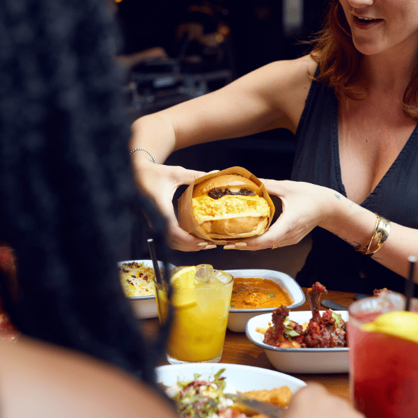 Guests enjoying a sandwich from Eggslut during Boxhall's bottomless brunch in Liverpool Street