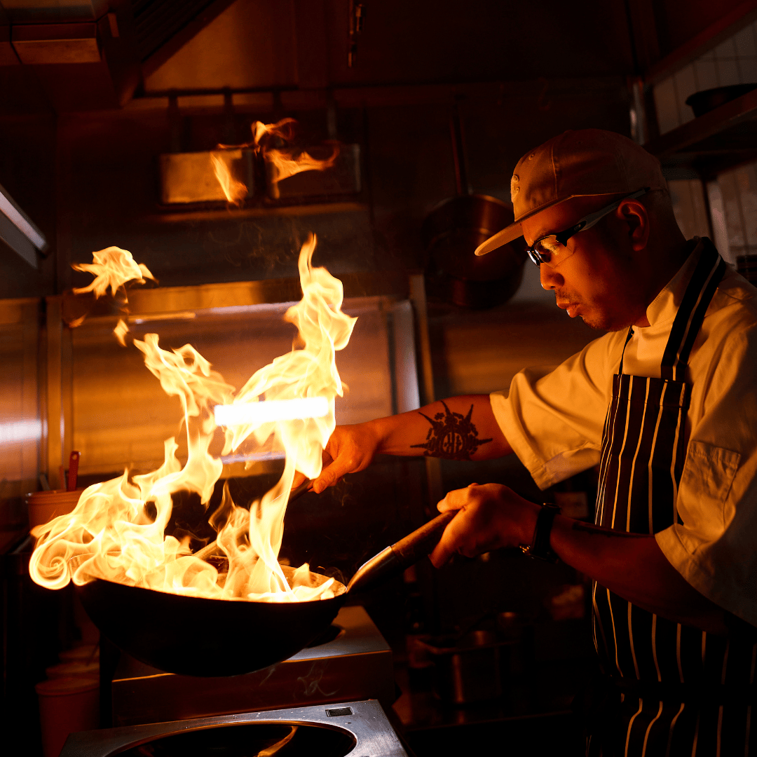 King male chef cooking with fire 