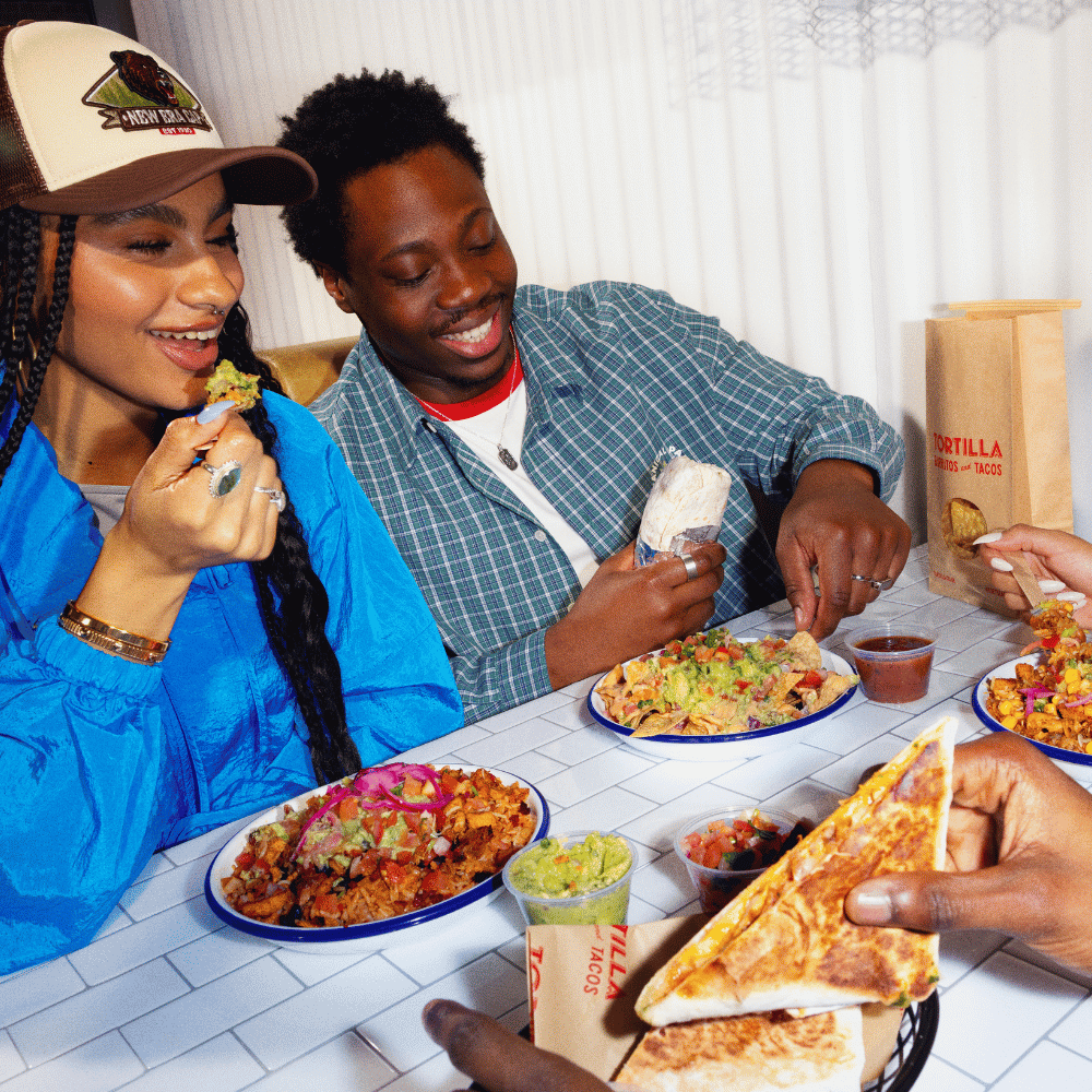 Guests eating a selection of food from Tortilla at BOXPARK.