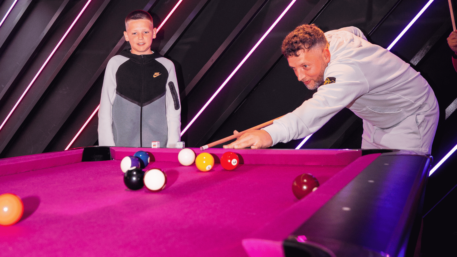 A father and son playing pool at Playbox in Croydon
