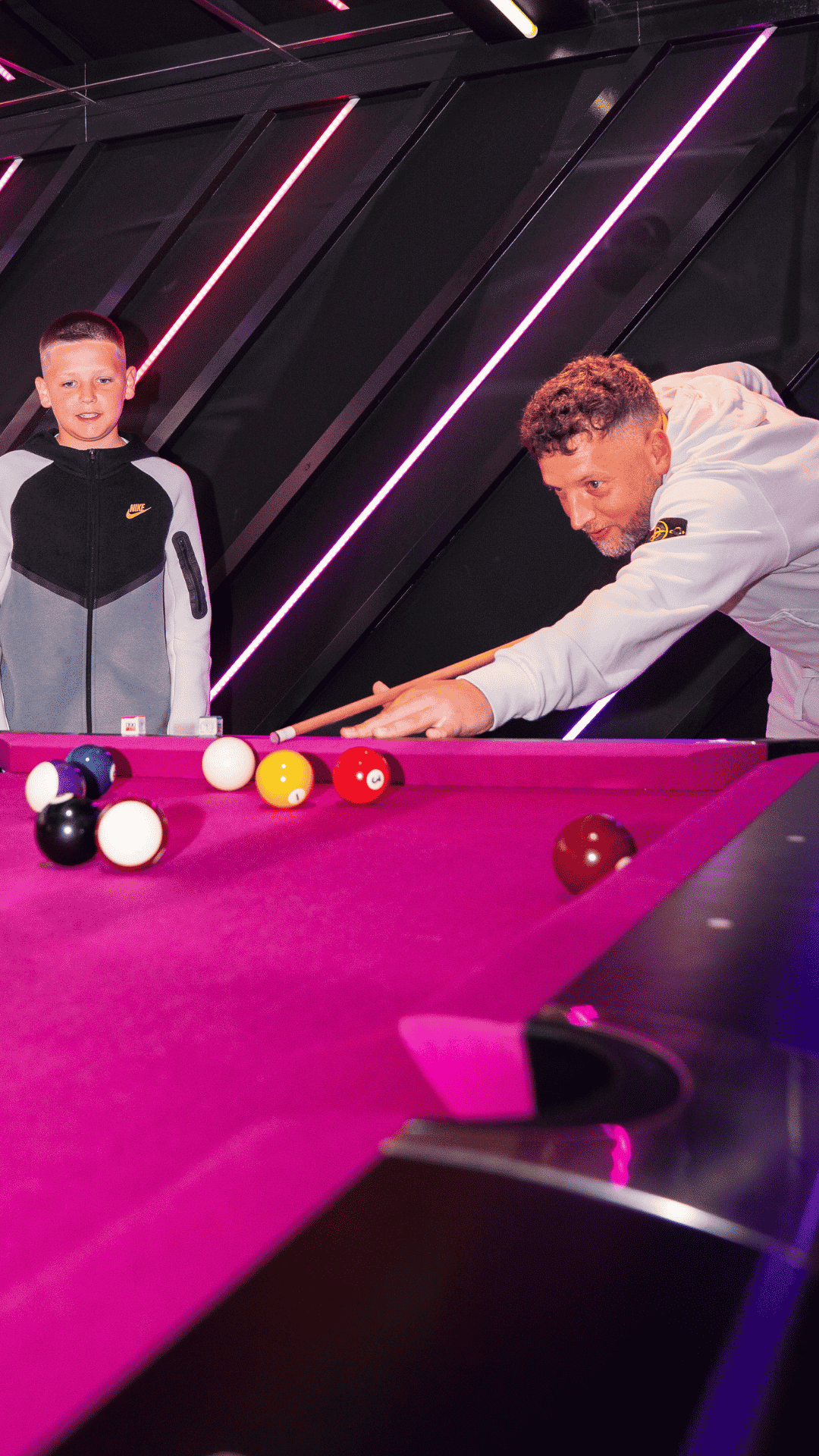 A father and son playing pool at Playbox in Croydon