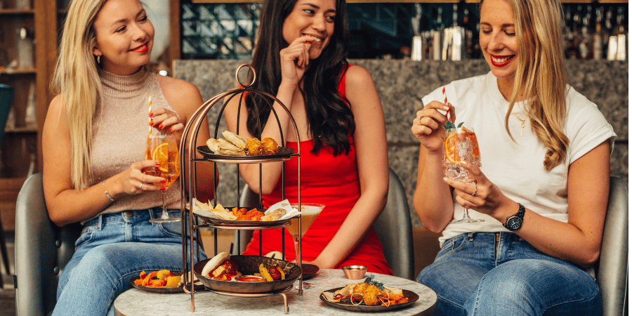 Women enjoying cocktails and food at Dirty Martini