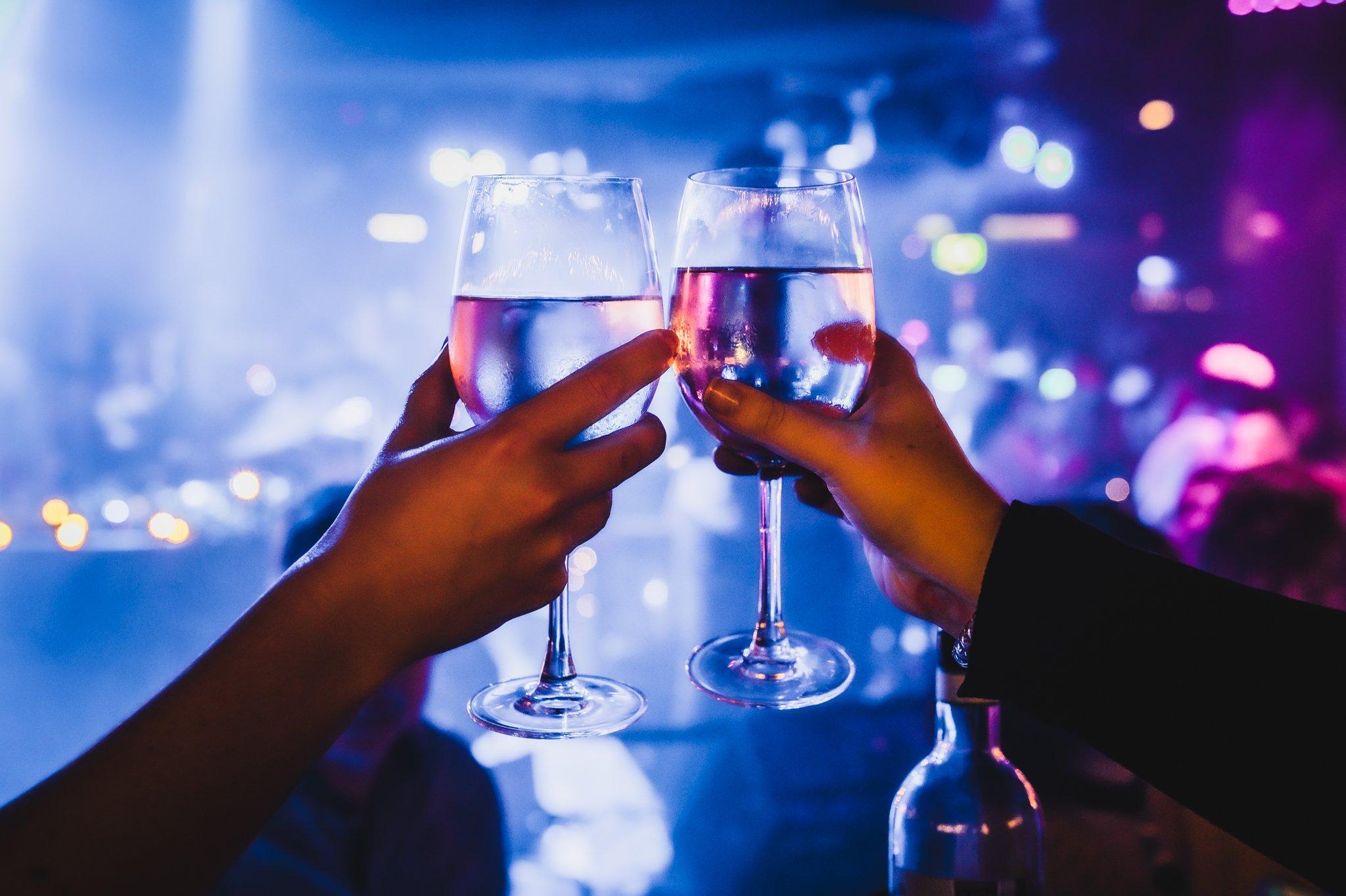 Close up of two wine glasses being held by customers at The Piano Works