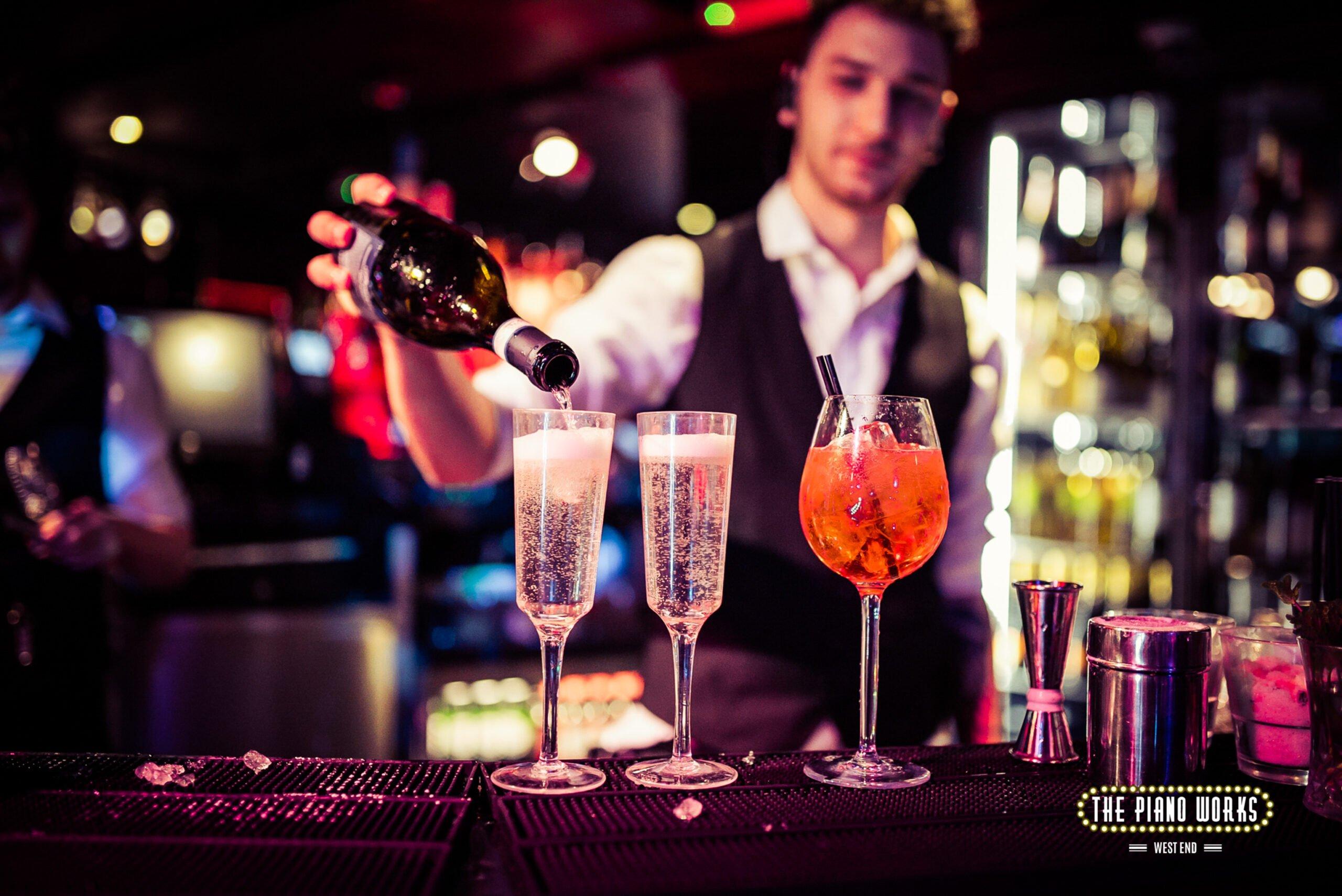 bartender pouring glasses of prosecco at Piano Works