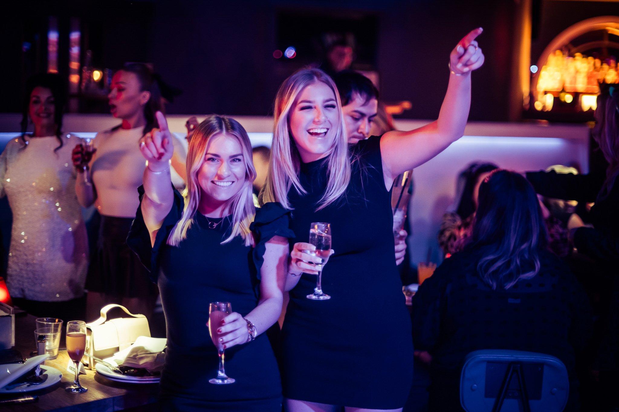 Two Female Guests Dancing and Drinking at The Piano Works