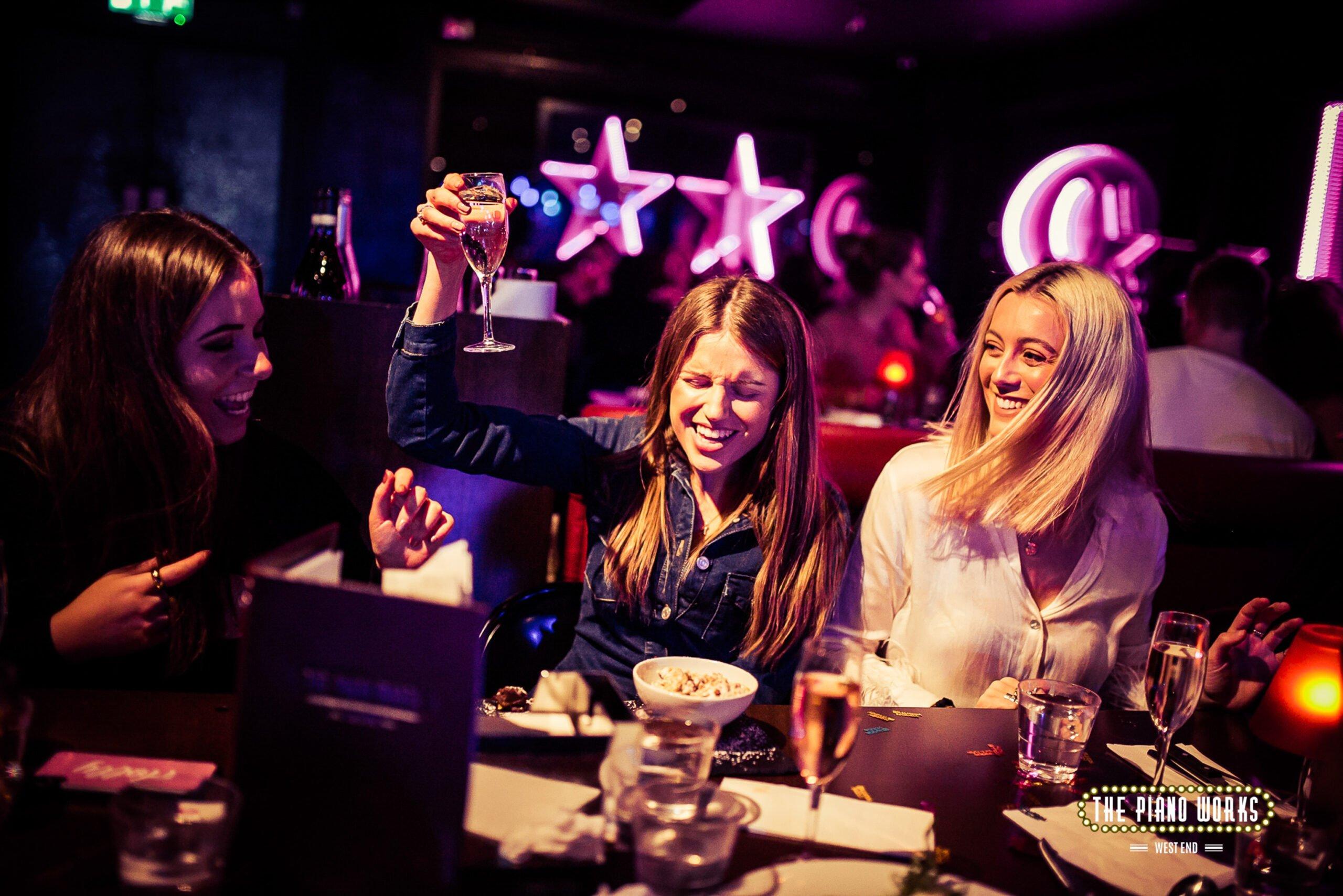 Customers having a good time in a booth at Piano Works