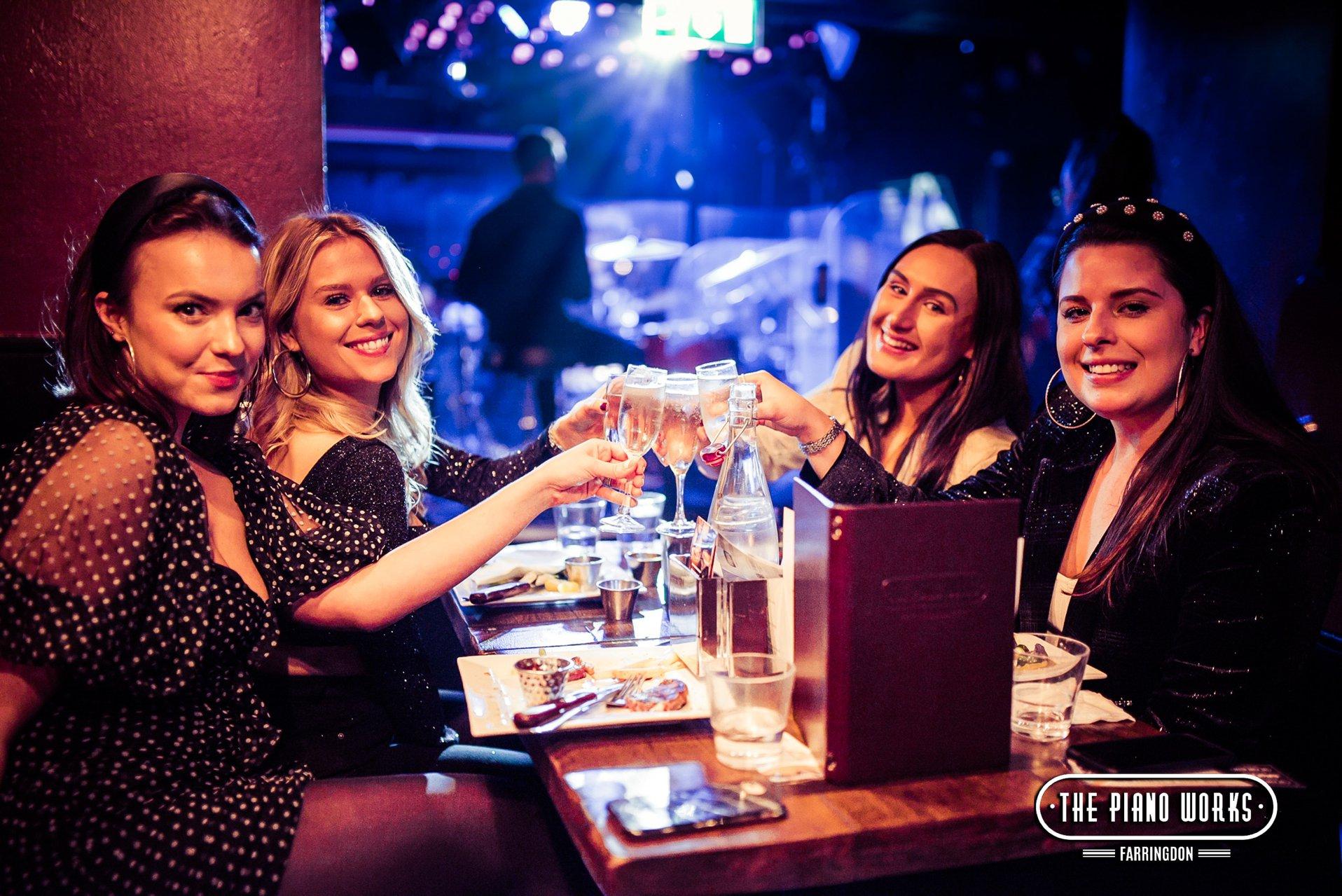 Customers enjoying prosecco and food in a booth at The Piano Works