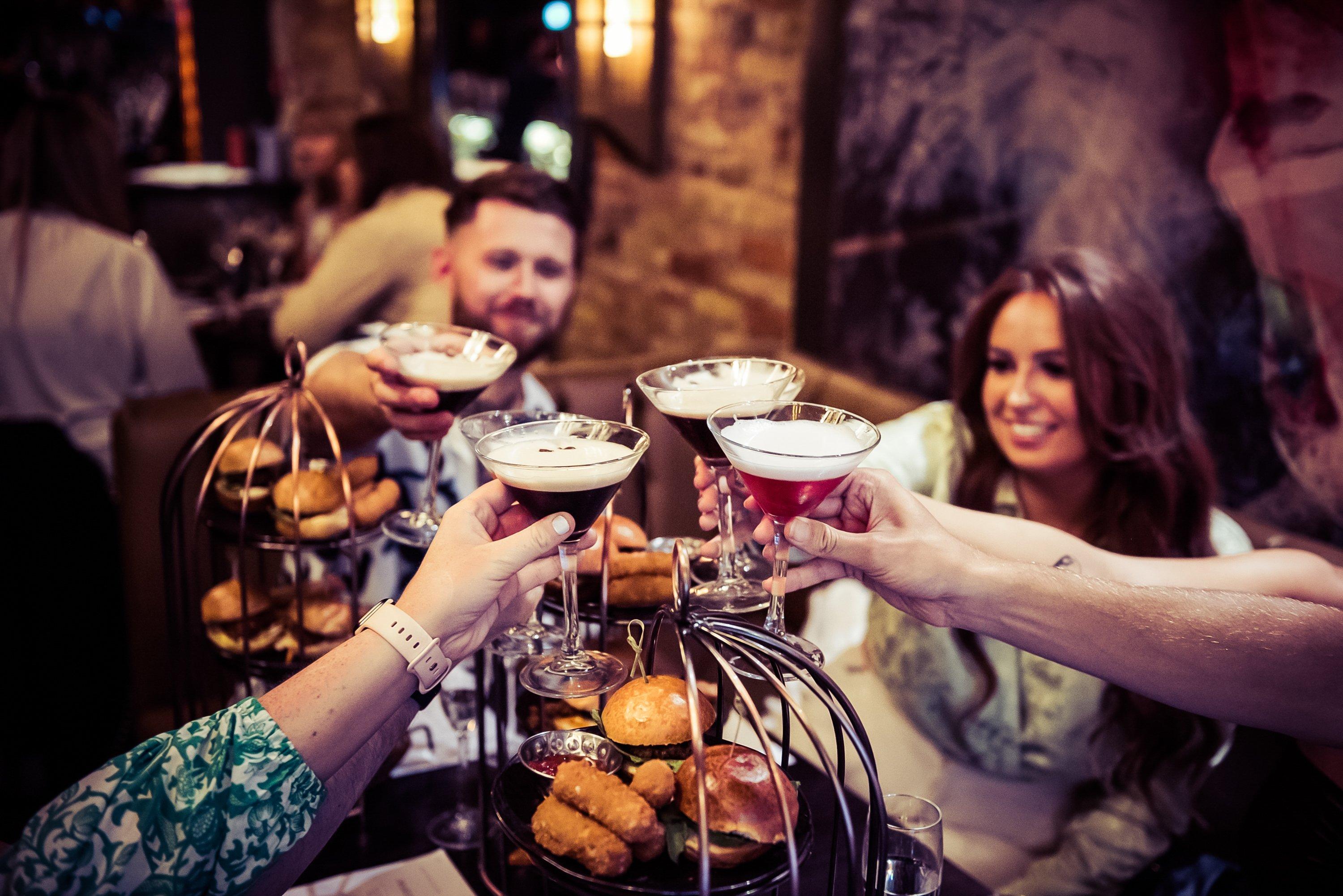 Guests clinking glasses at a bottomless brunch event in Dirty Martini