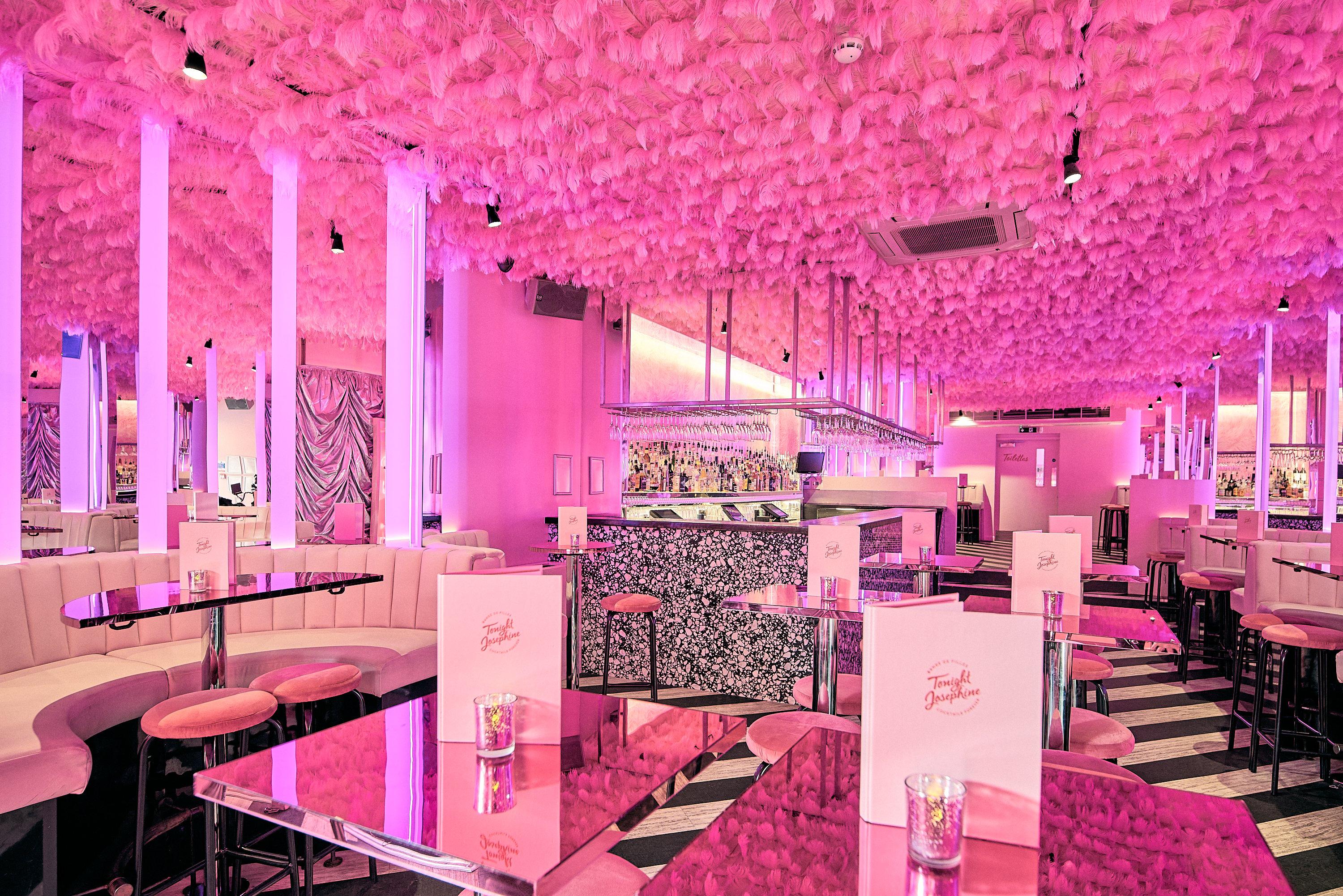 A bar area with mirrored walls and a feather ceiling