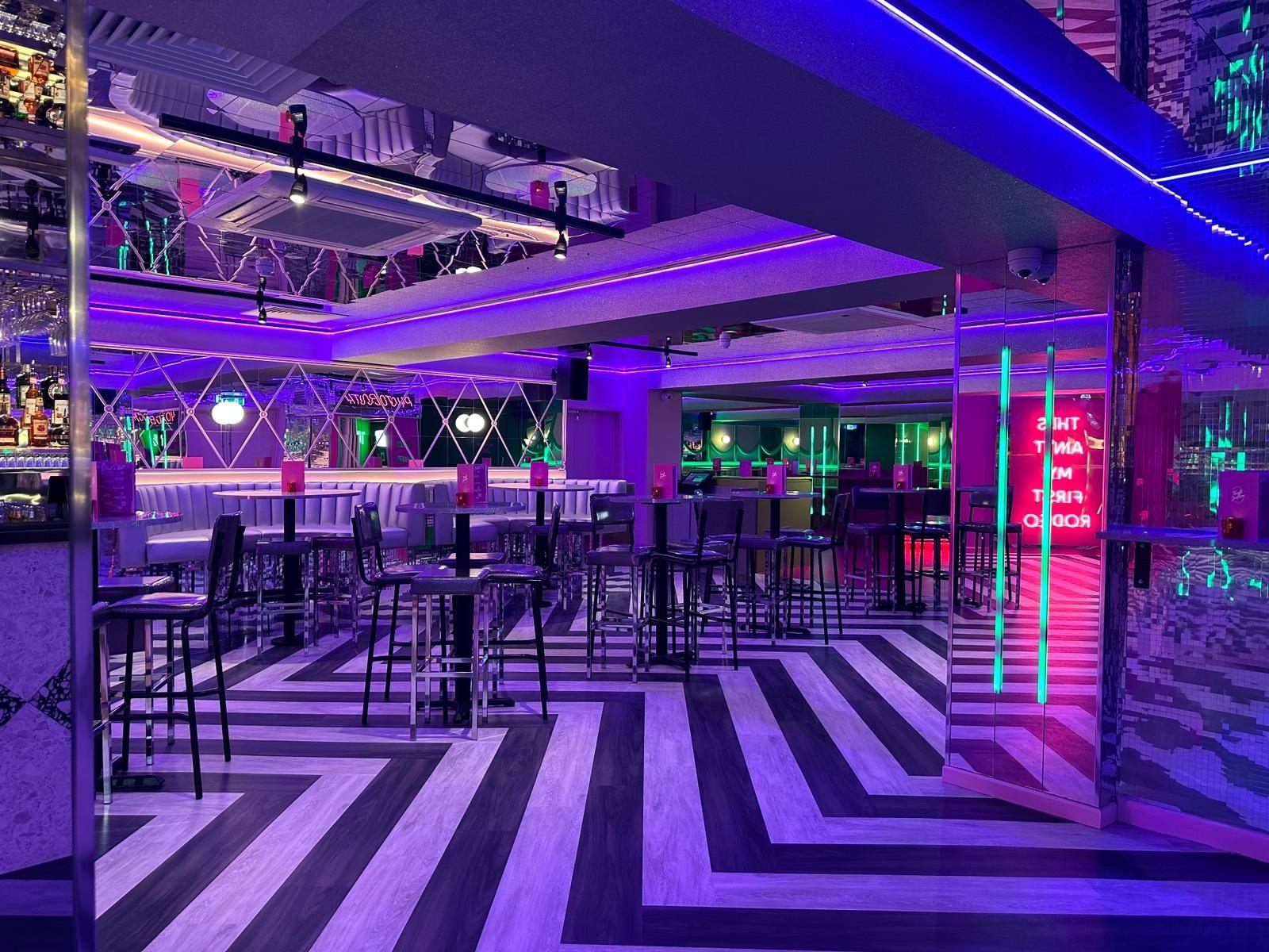 An area of Tonight Josephone in Liverpool with tables and chairs and mirrored walls