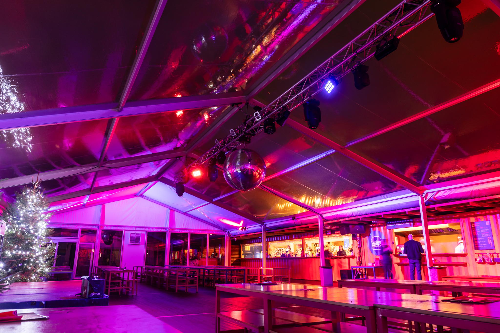 A heated marquee with a giant disco ball and bar area