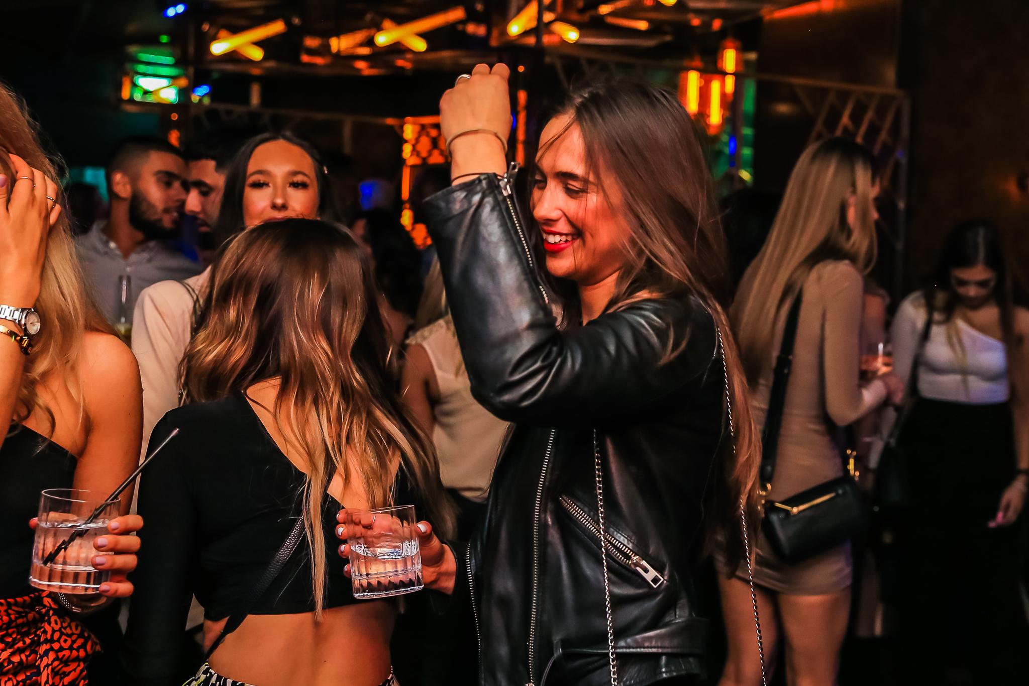 Women drinking and dancing in Dirty Martini