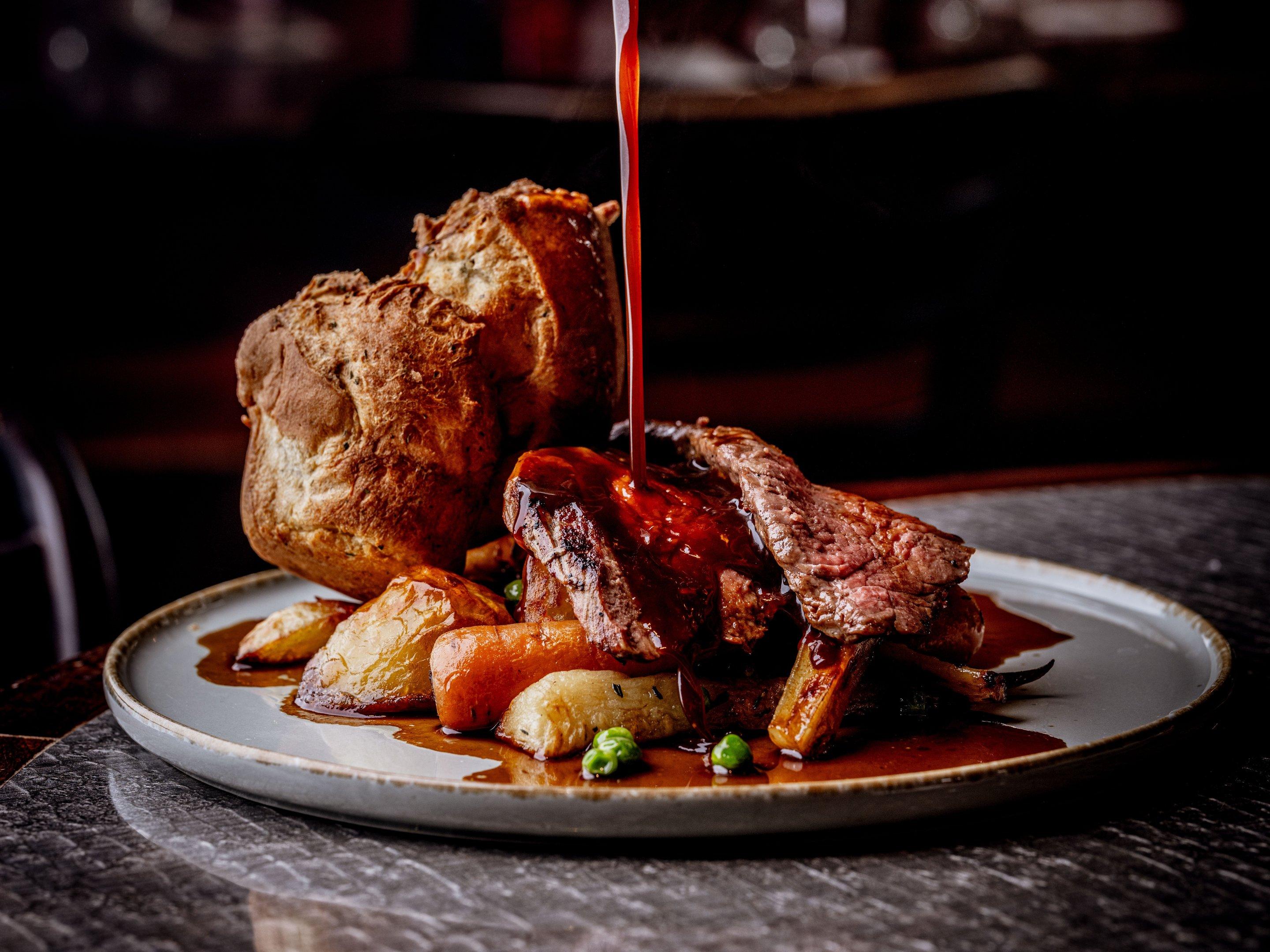 Gravy being poured over a Sunday Roast dinner at Tuttons in Covent Garden