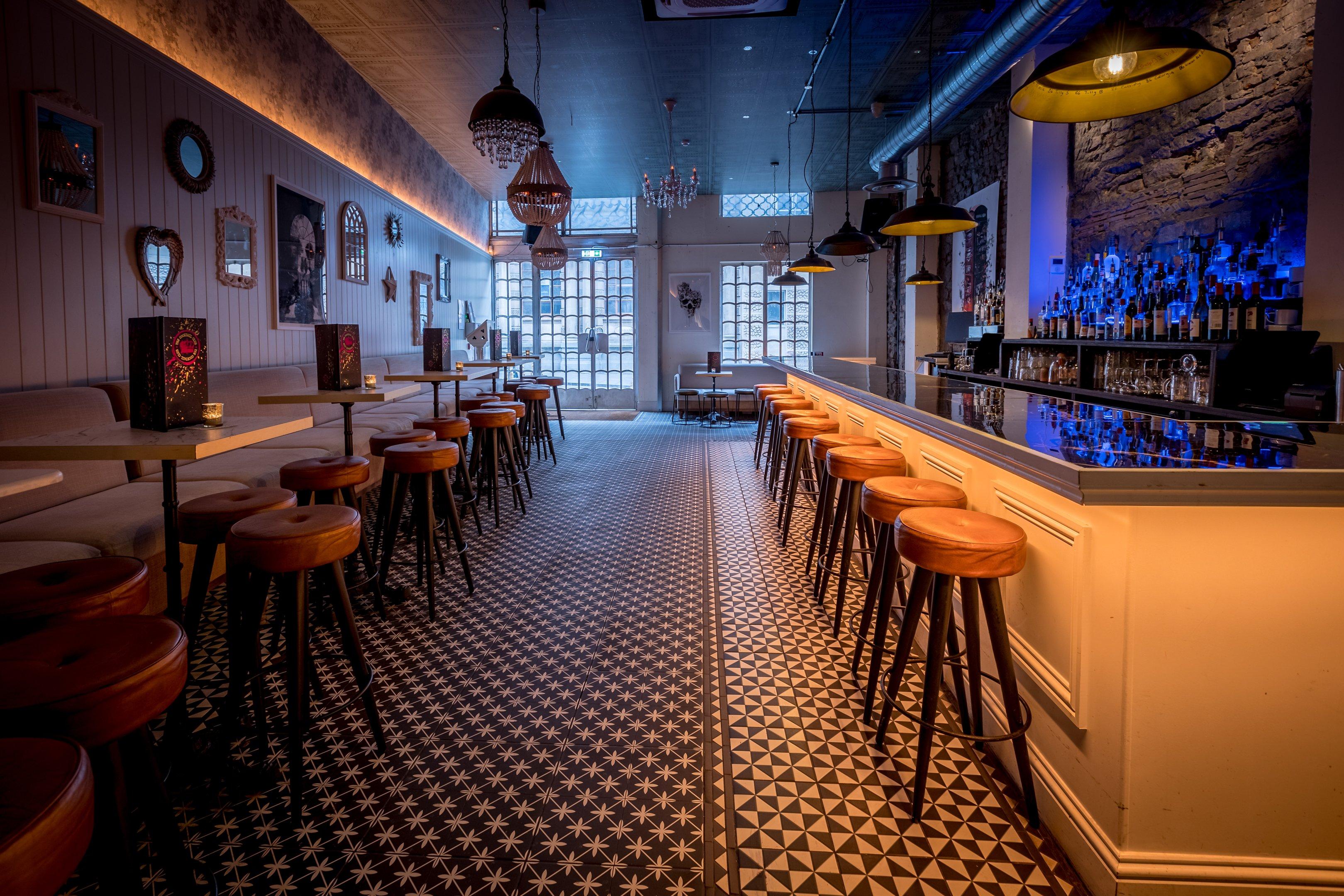 A bar with mosaic flooring and stool seating