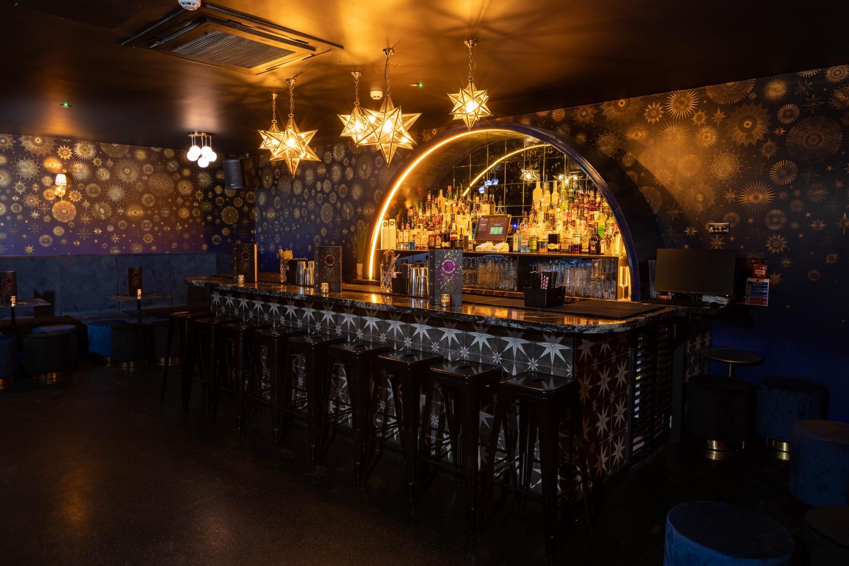 A private bar area with navy walls and star decor