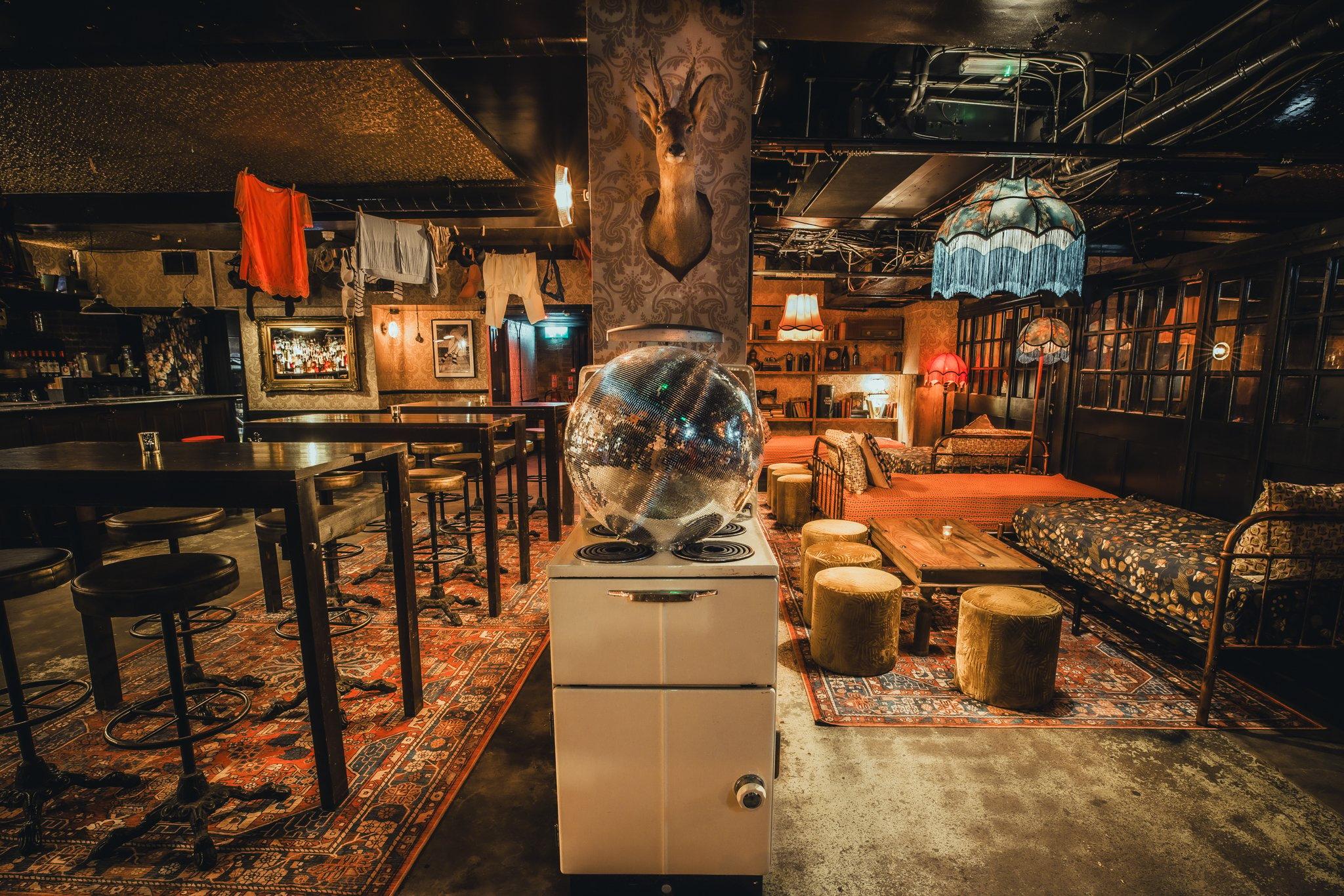 A bar decorated with retro home decor with stools and bar seating