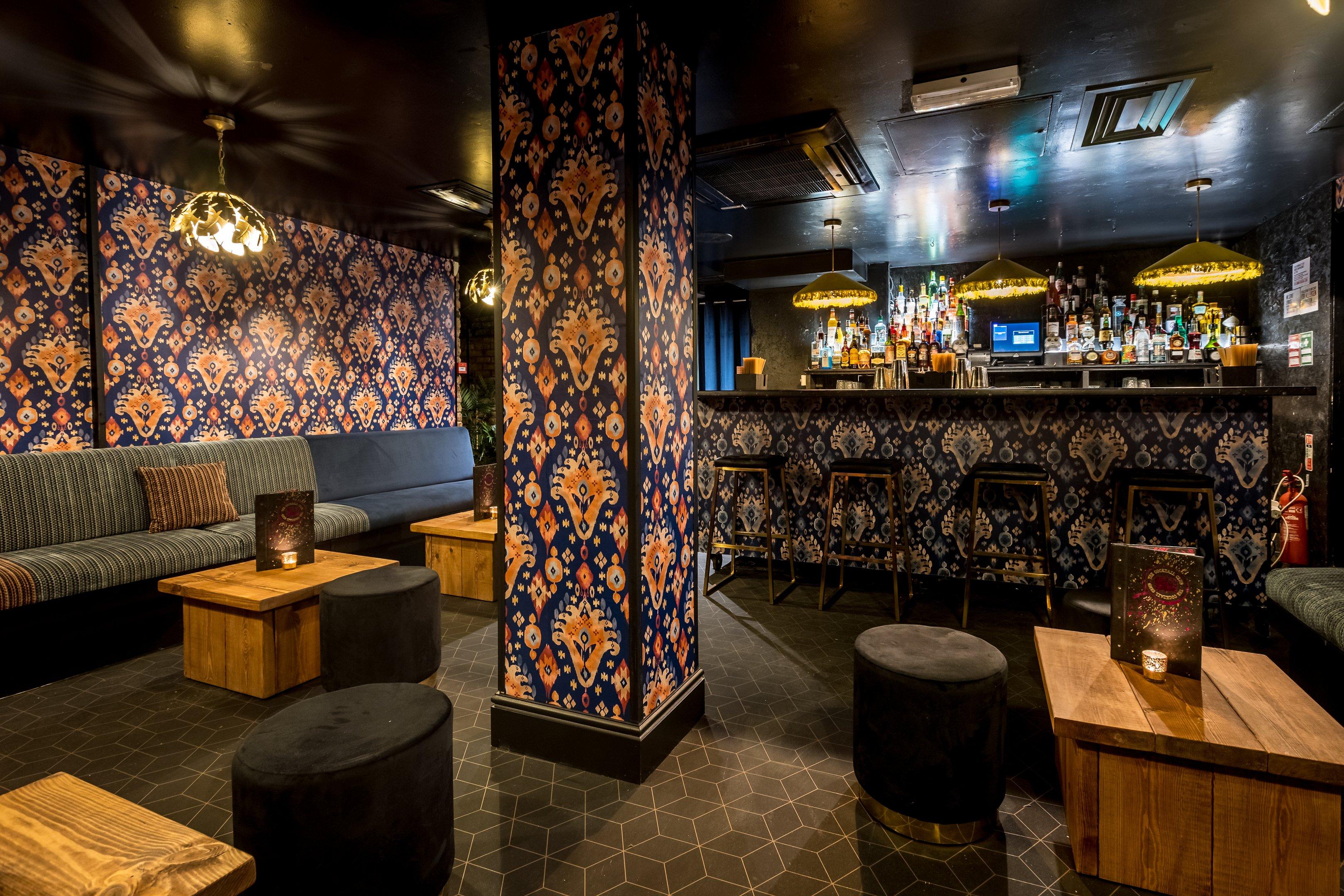 Private bar area with bold patterned walls and a private bar