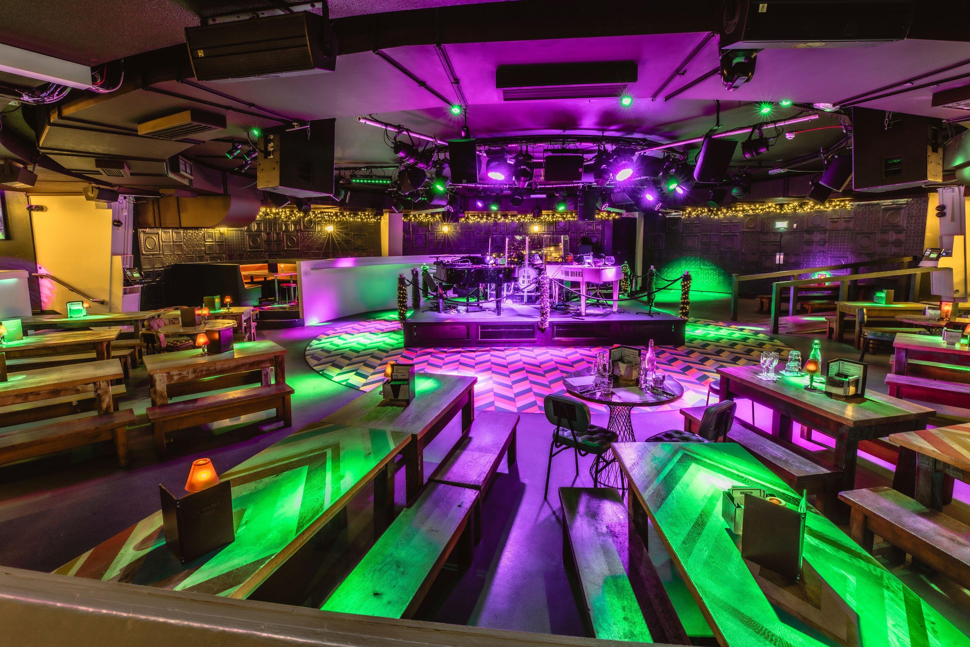 An interior shot of The Piano Works in Covent Garden with a stage and bench seating