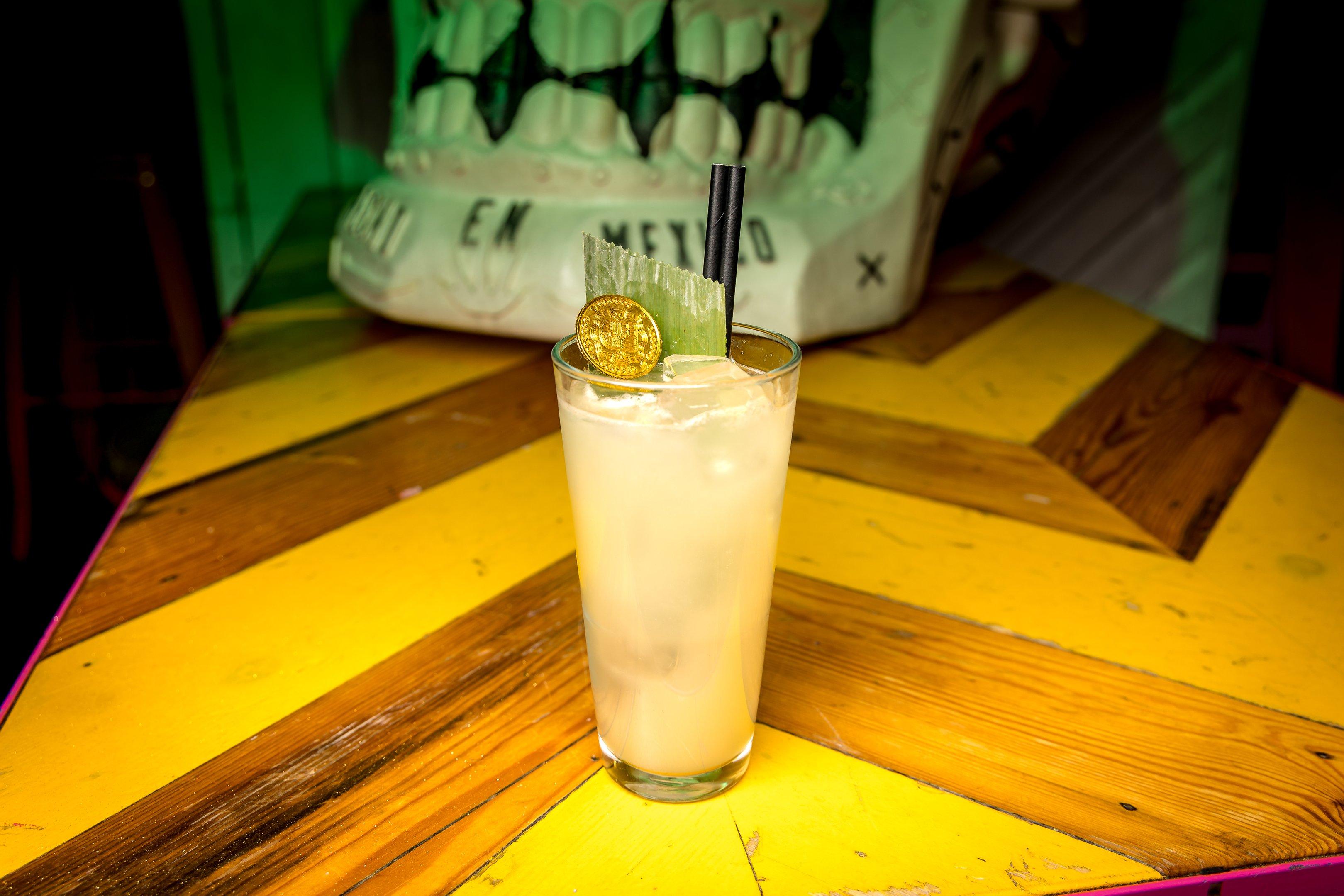 Image of a Halloween cocktail with a gold coin garnish