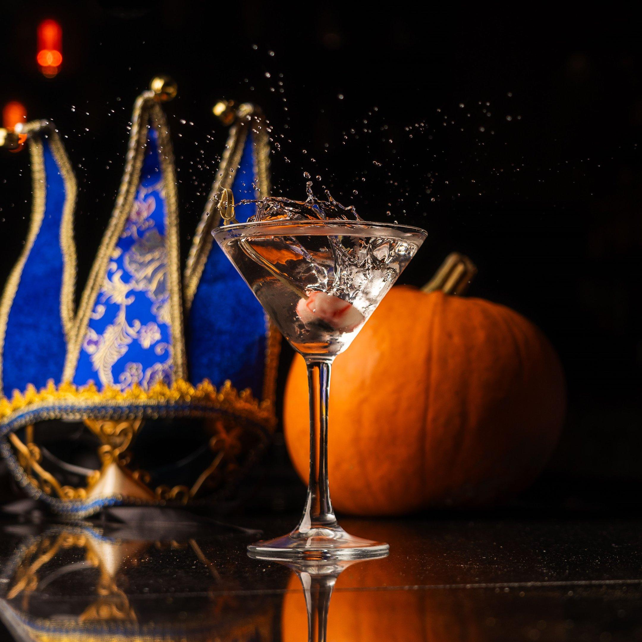 An image of an eyeball garnish being dropped into a cocktail in a martini glass