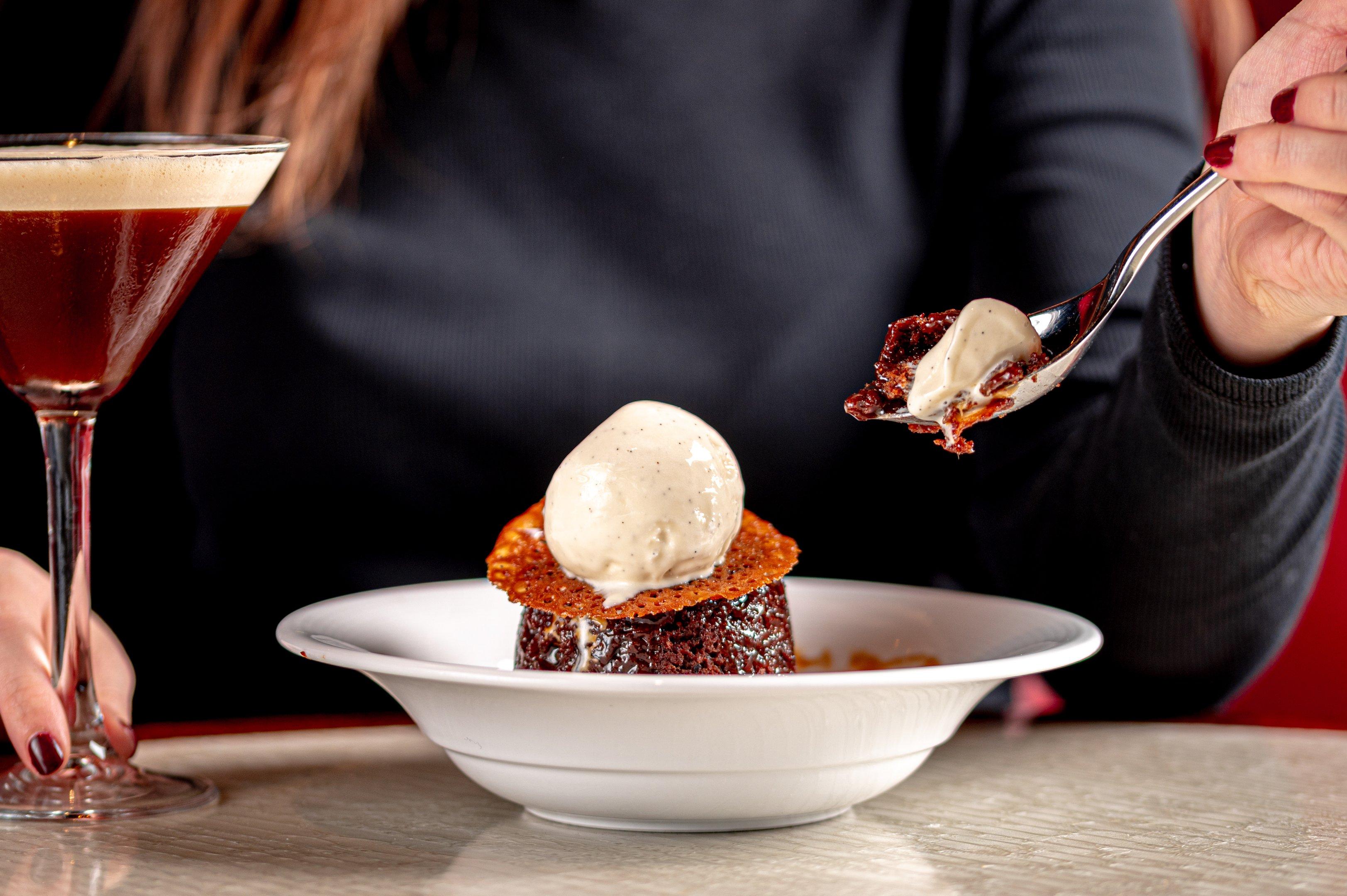 A customer with a dessert and cocktail in Tuttons restaurant