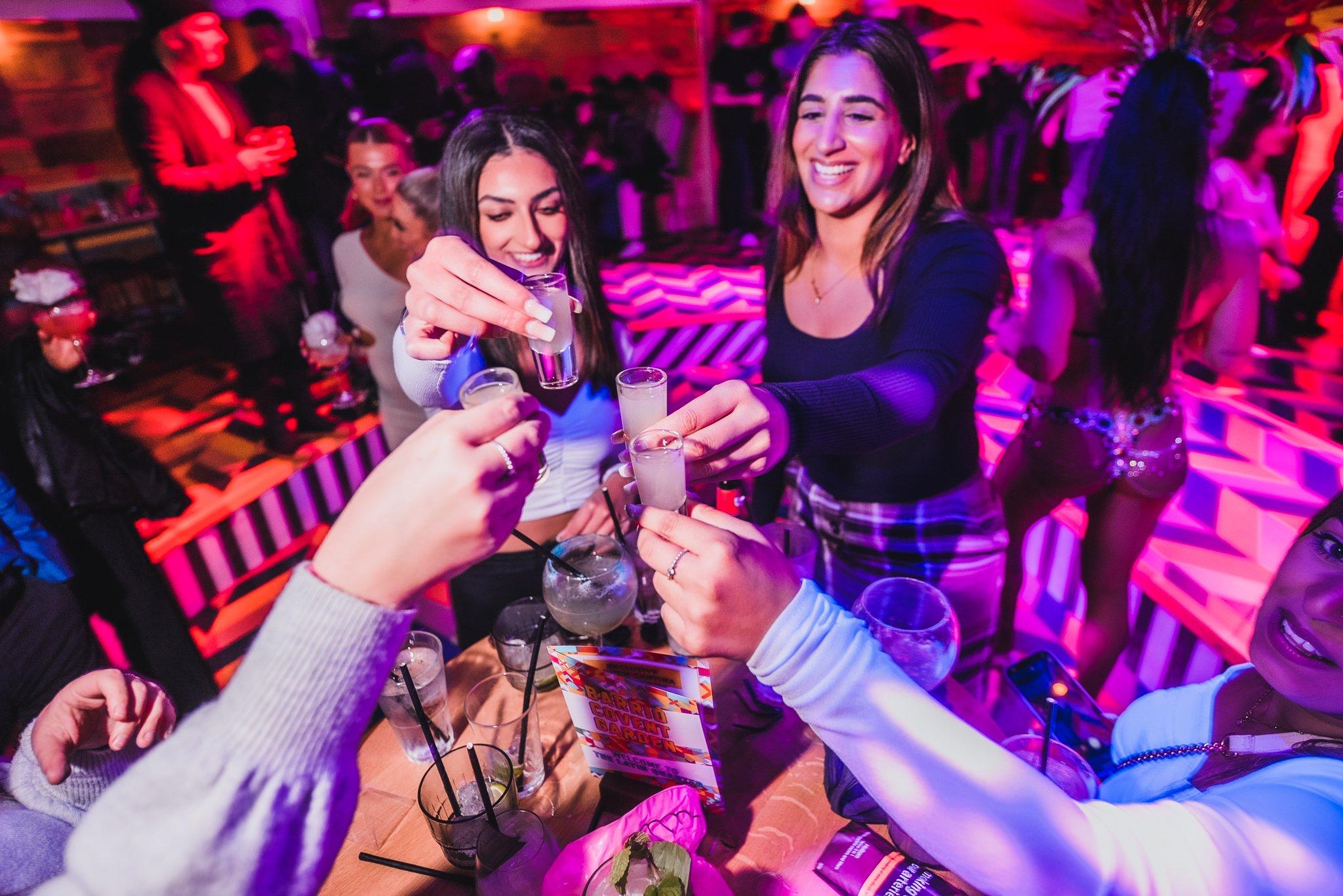 Women enjoying shots at their table in Barrio