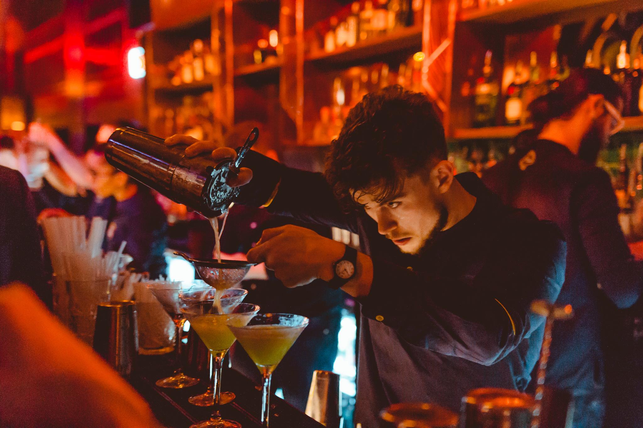 A bartender pouring Martini cocktails at Dirty Martini