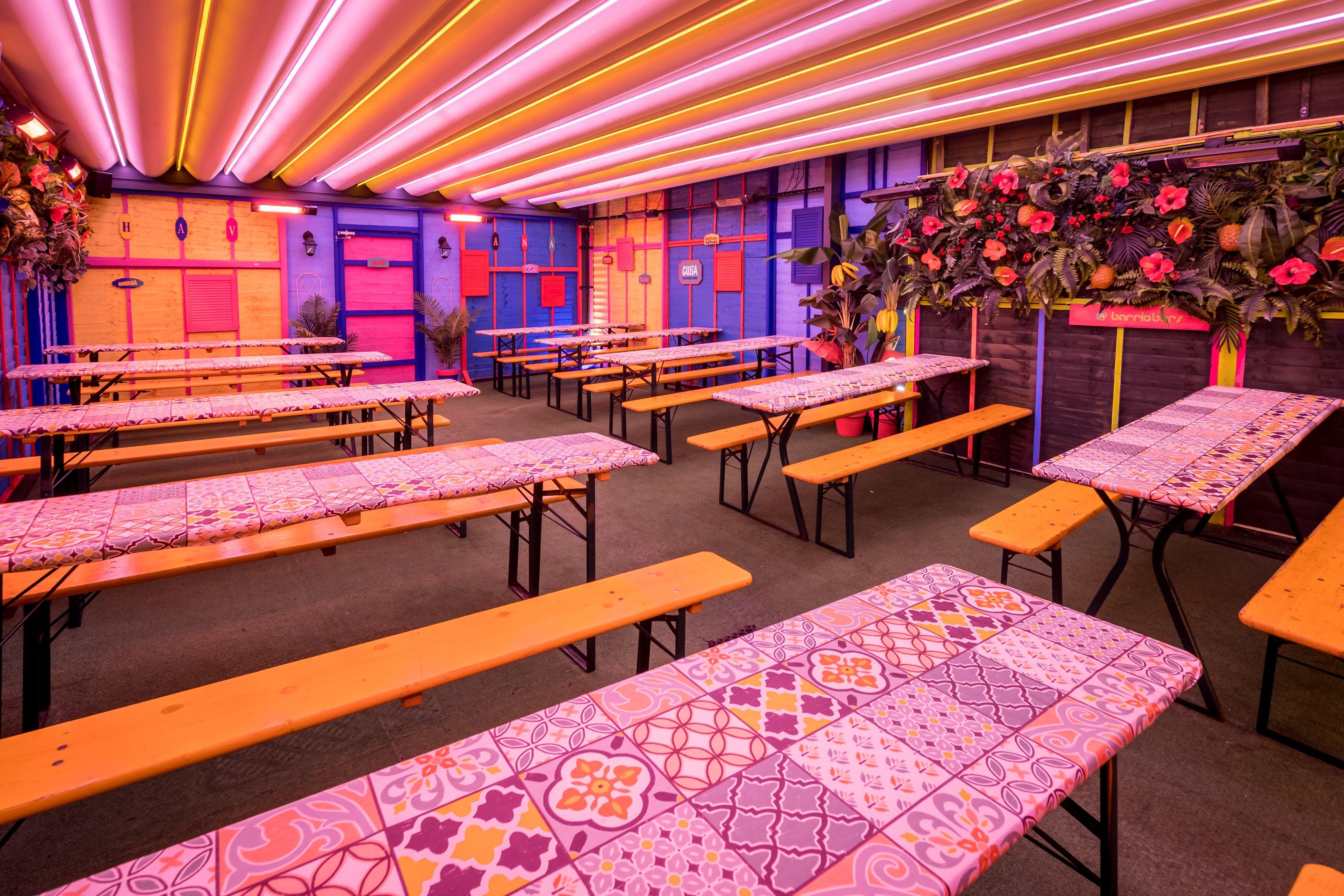 Bench seating with a neon light ceiling at Barrio Shoreditch