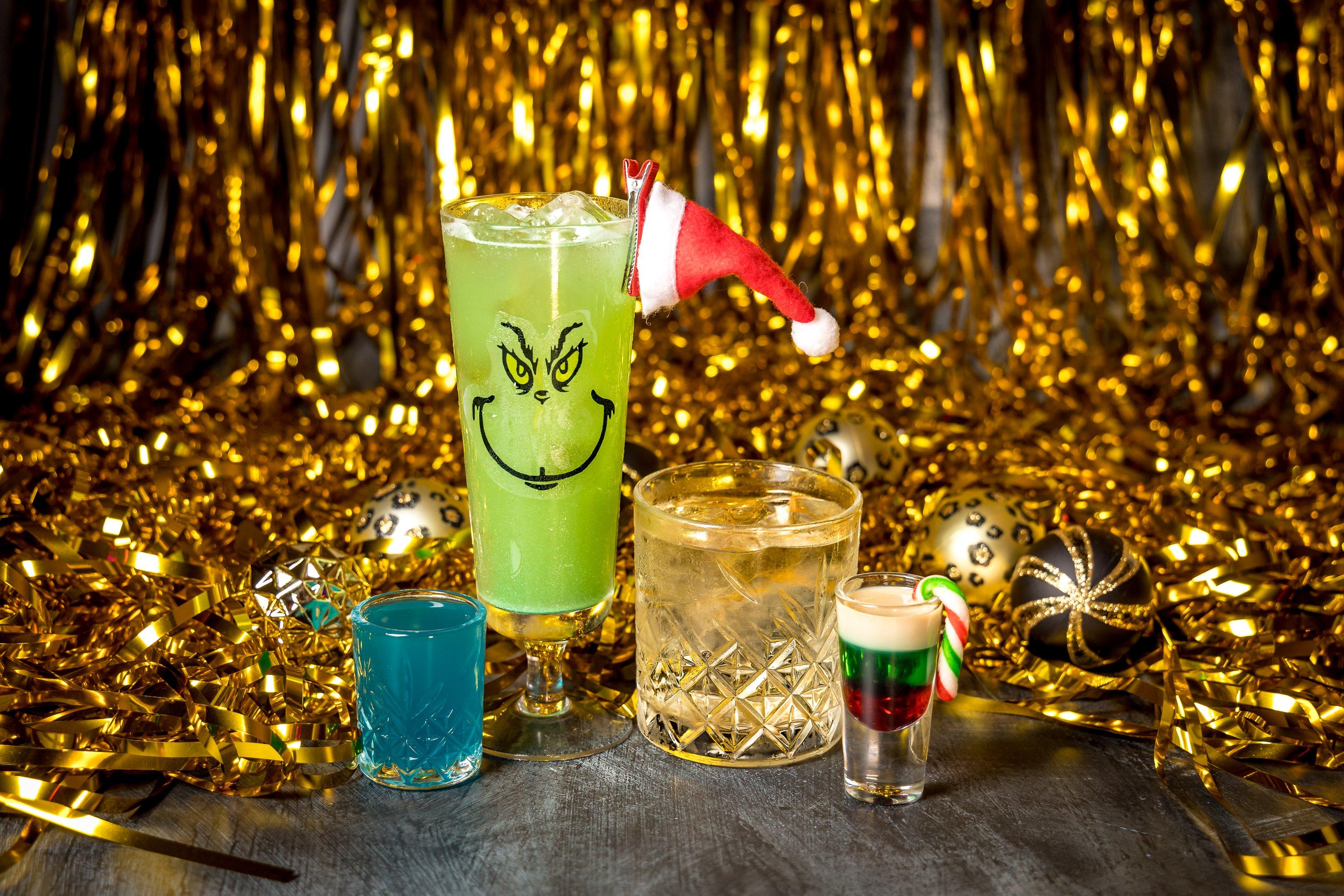 A group of Christmas cocktails in front of a gold tinsel background