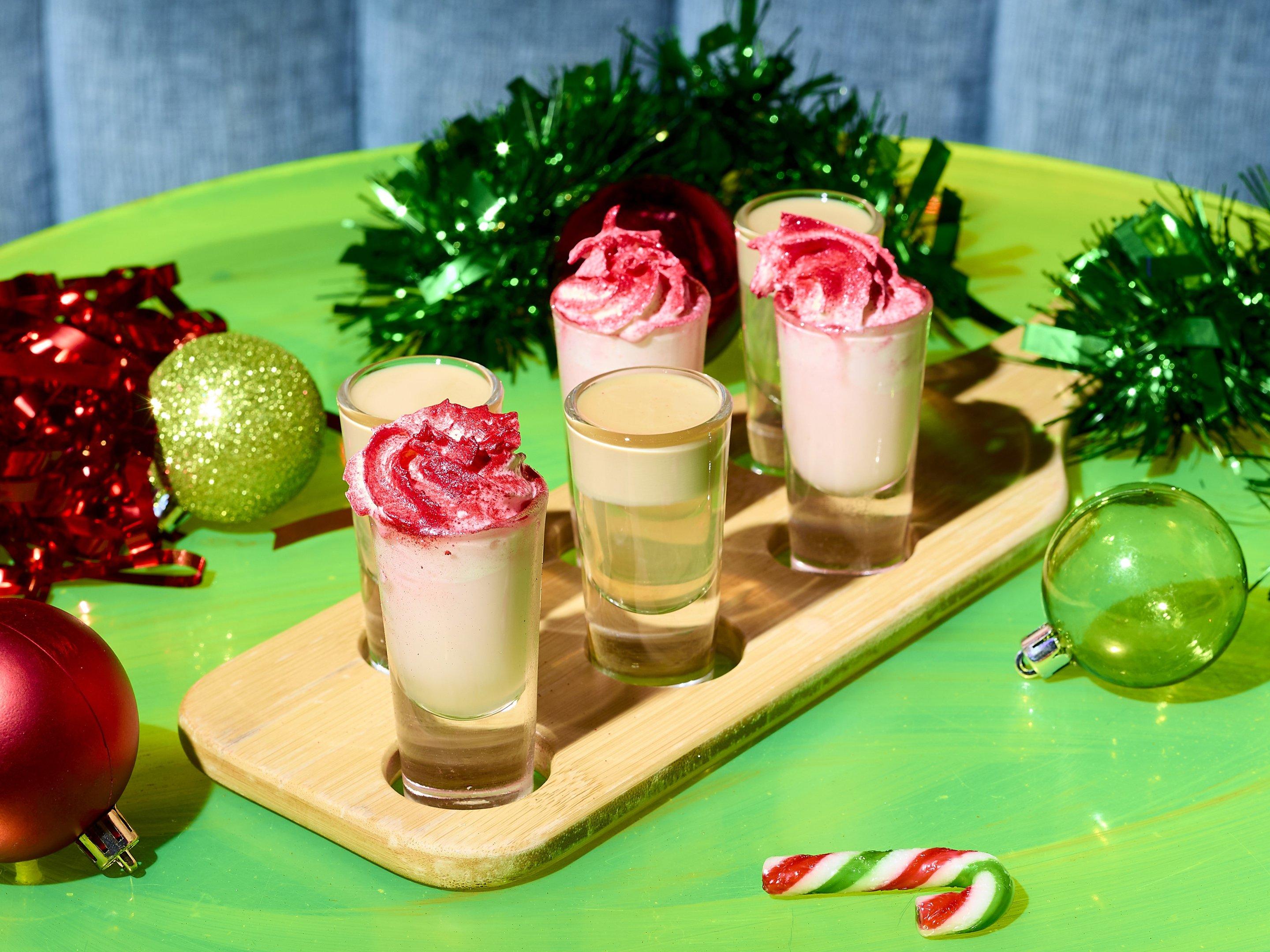 A shot paddle with six Christmas shots on a festive table
