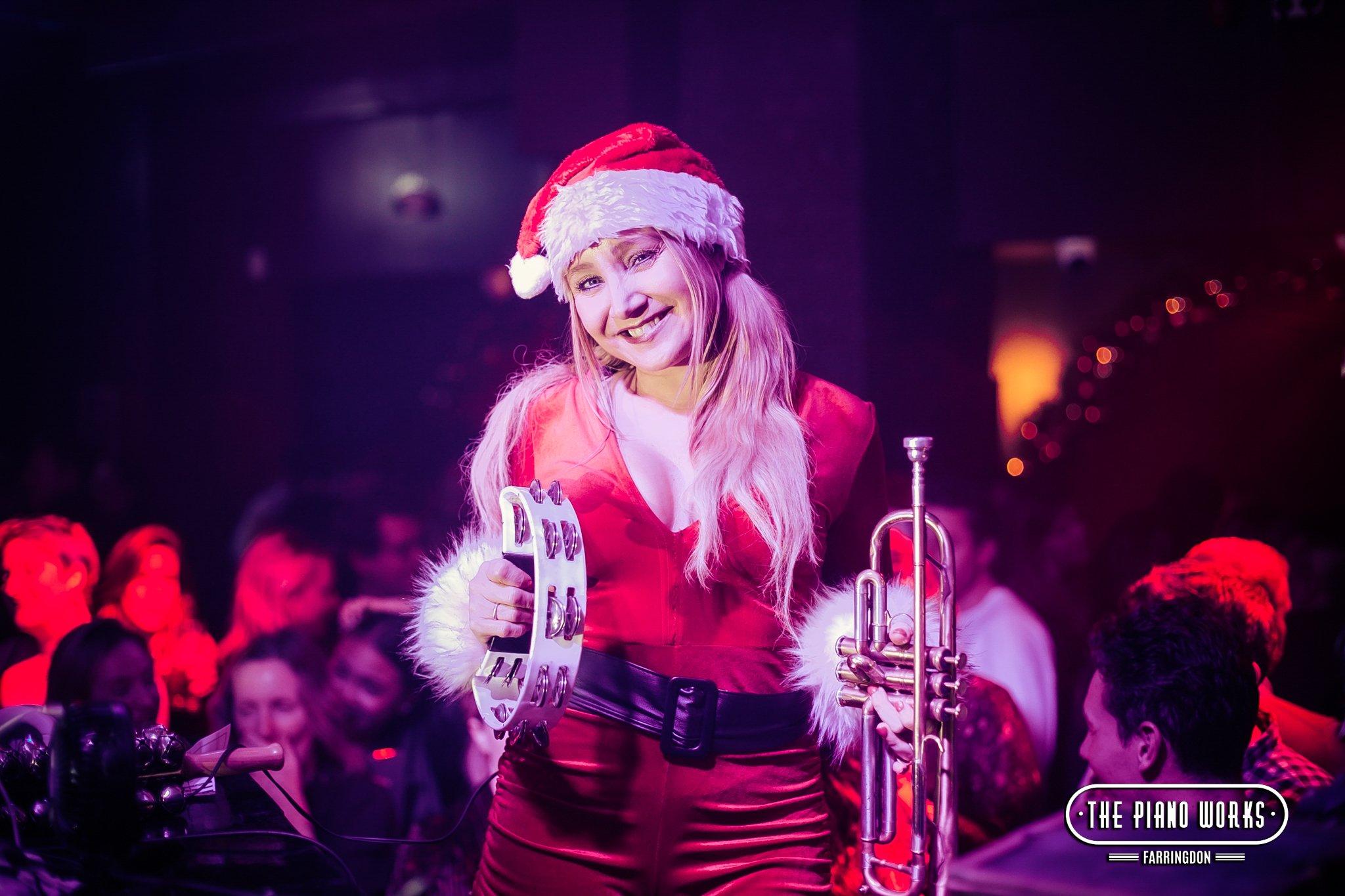 Trumpeter Dressed as Mrs Claus at Piano Works in London