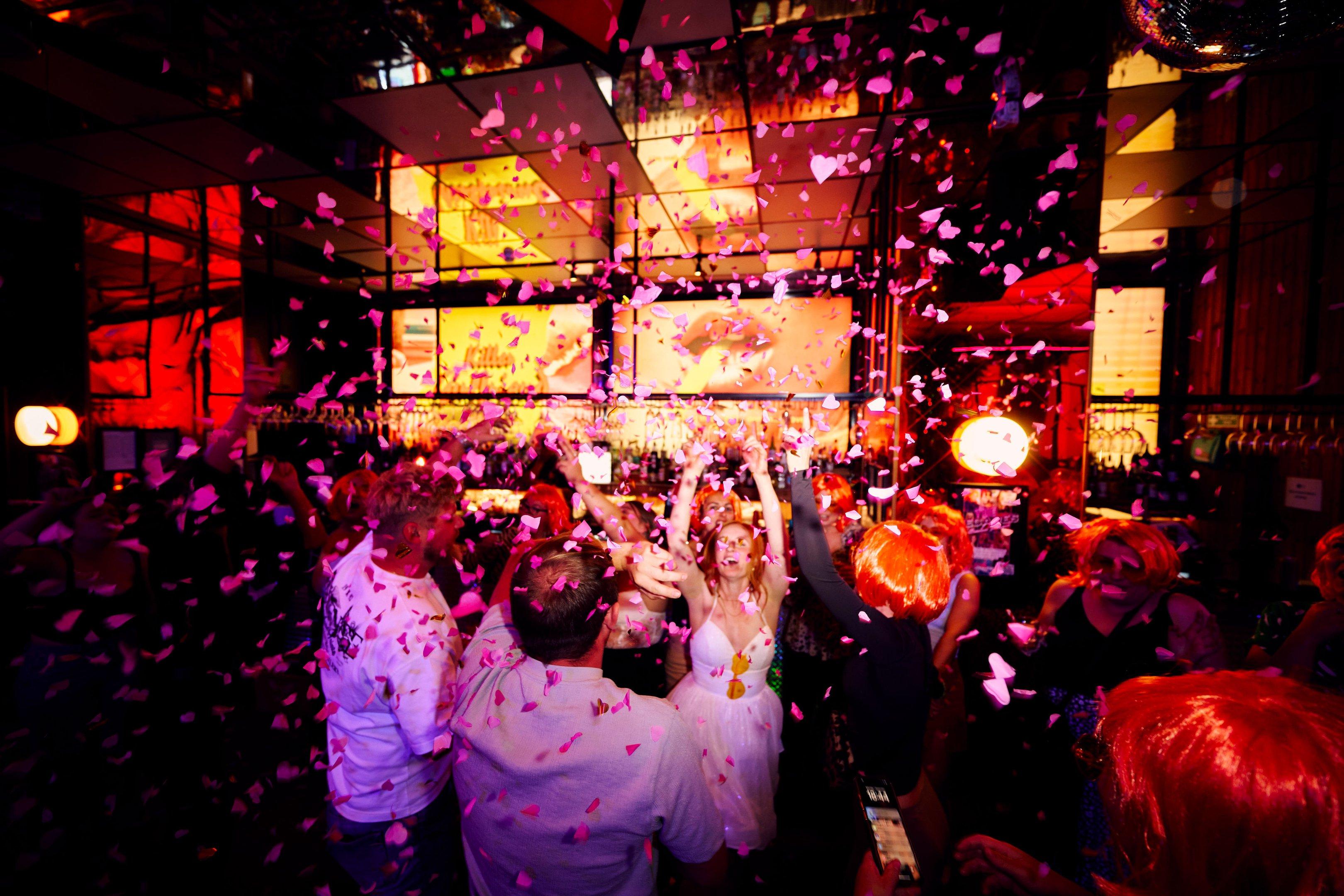 Guests dancing in falling confetti in Nikki's bar