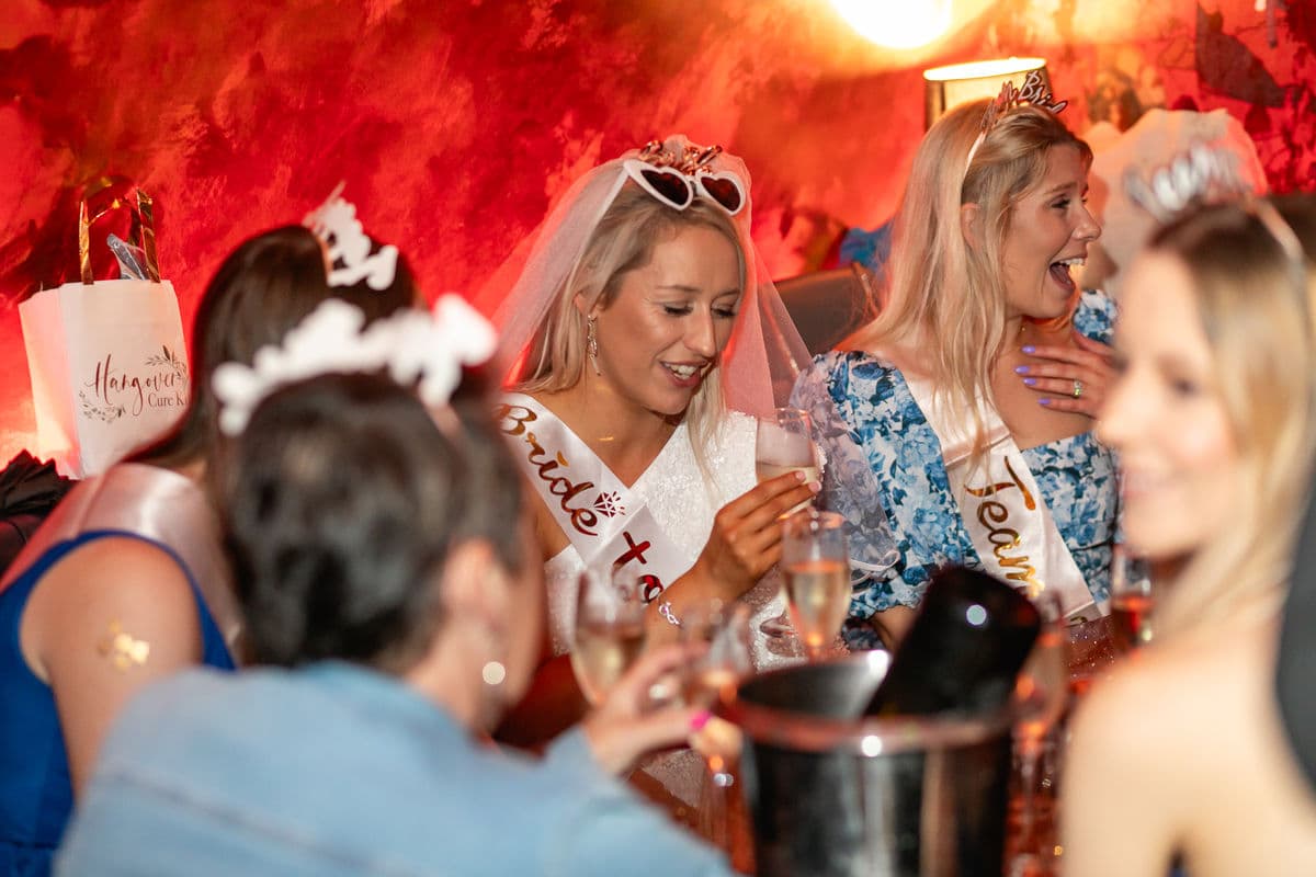 A bride sitting at a table sipping prosecco in The Escapologist