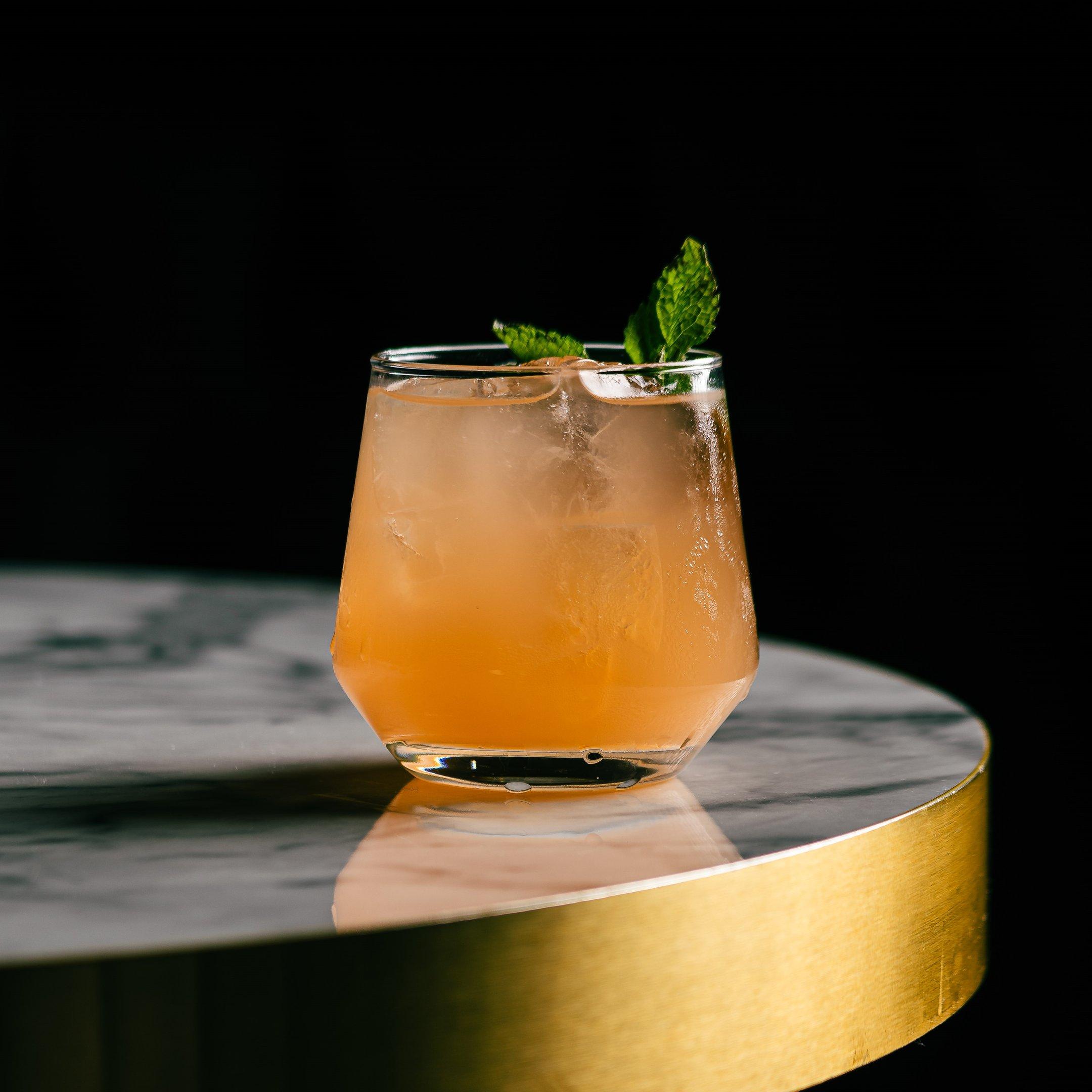 A close up of a mocktail in a short glass on a table in Dirty Martini