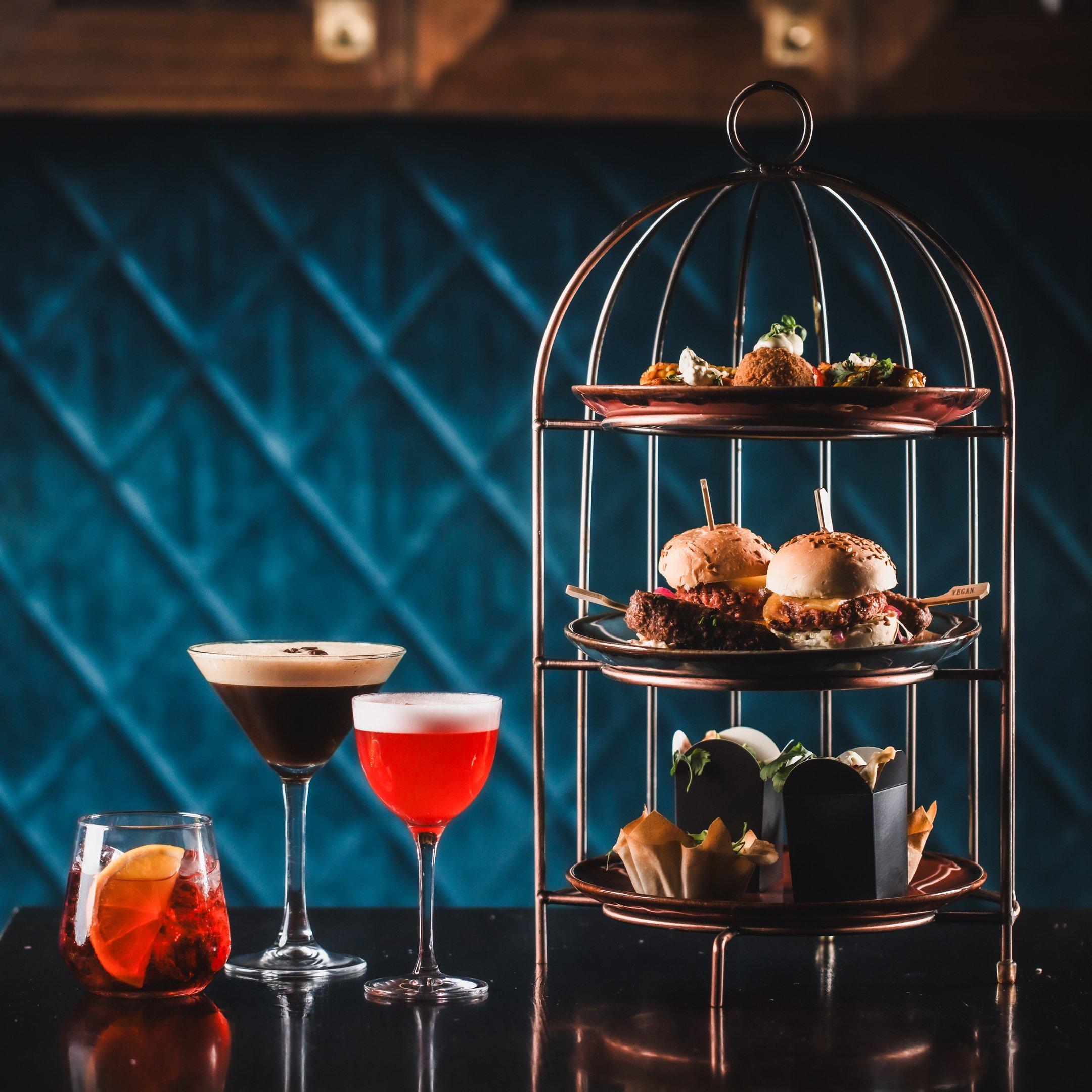 A birdcage food sharer with 3 cocktails in Dirty Martini