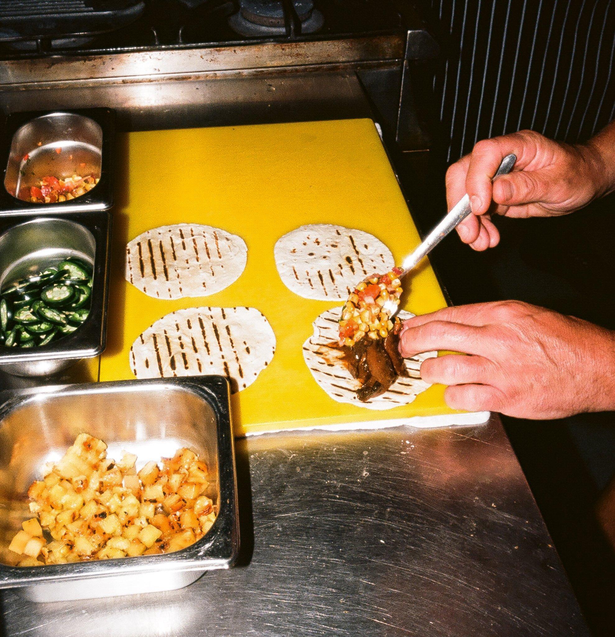 Tacos being prepared in the kitchen in Barrio