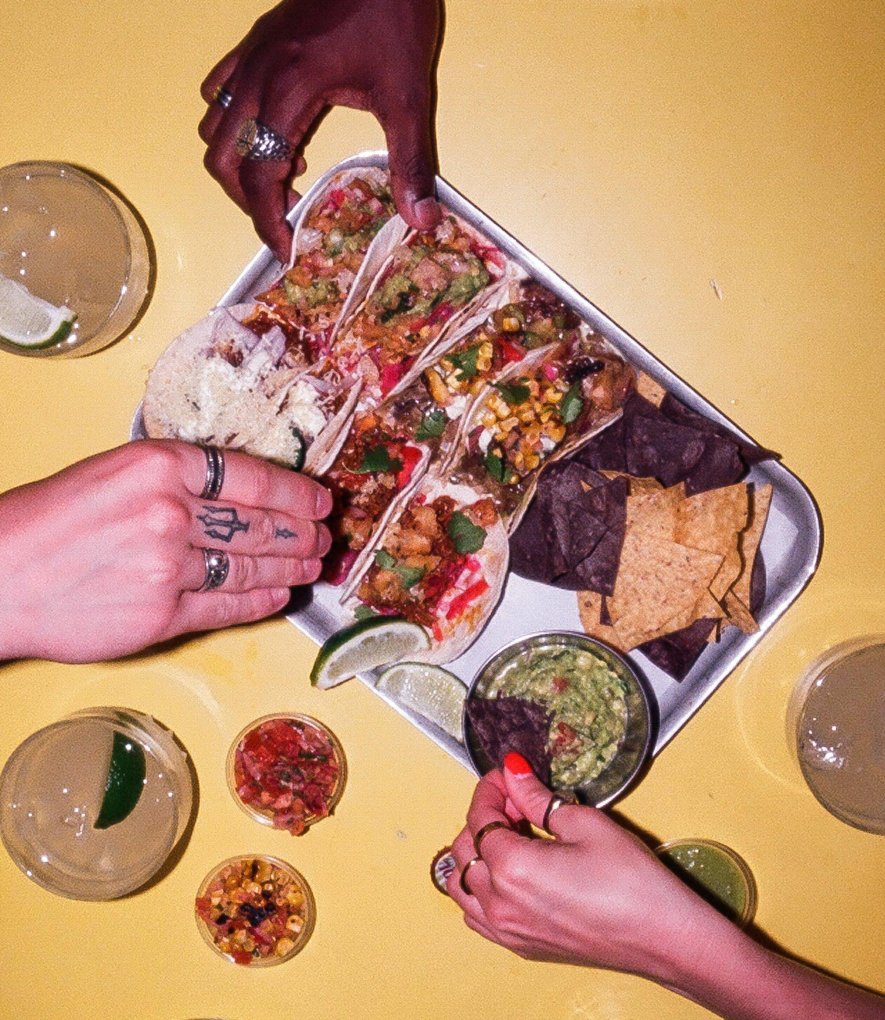 A platter of Tacos and Tommy's Margaritas on a table in Barrio