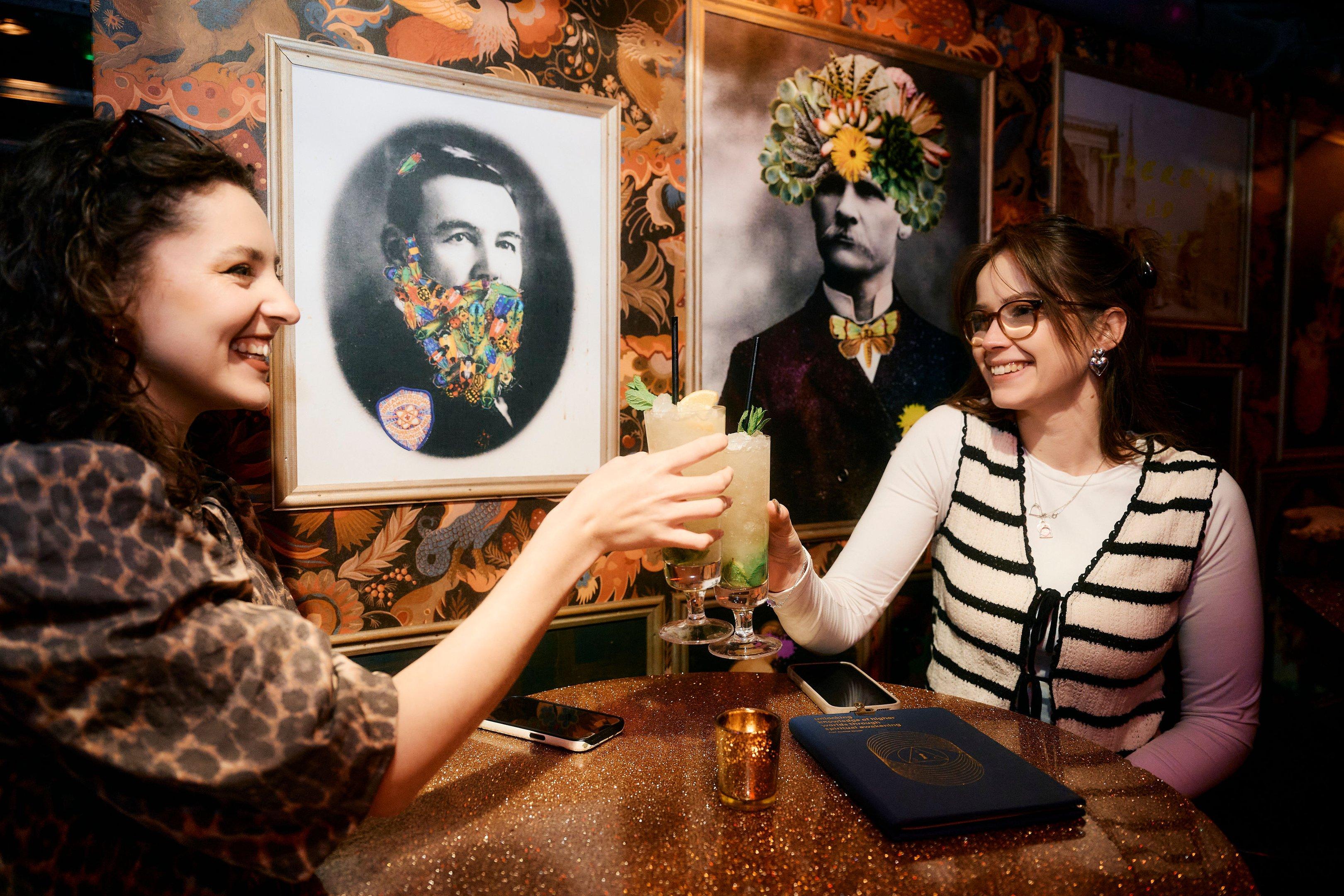 Two guests enjoying cocktails at a table in The Escapologist