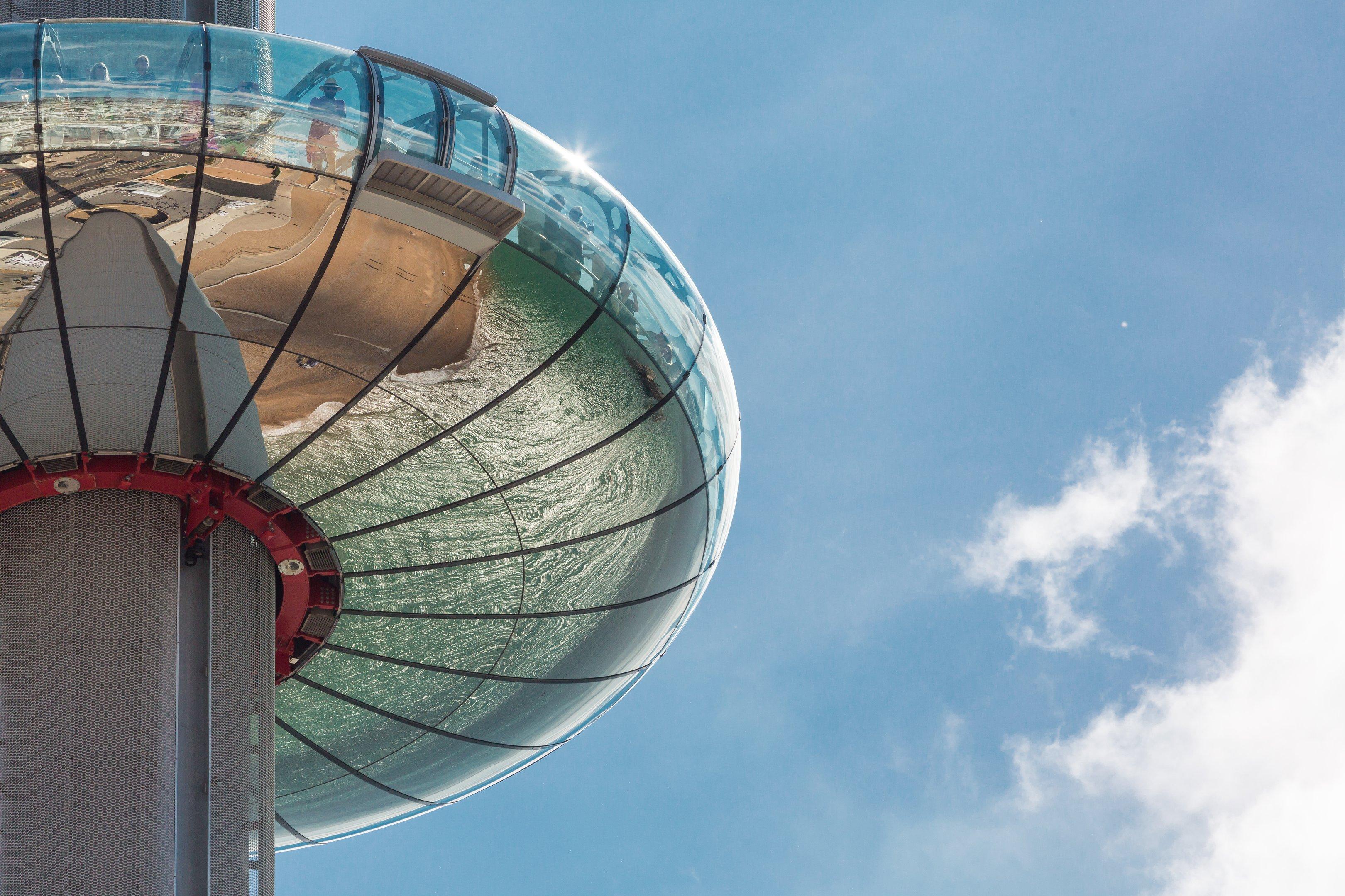 A shot of the underside of the Brighton i360 showing a reflection of the beach and sea below