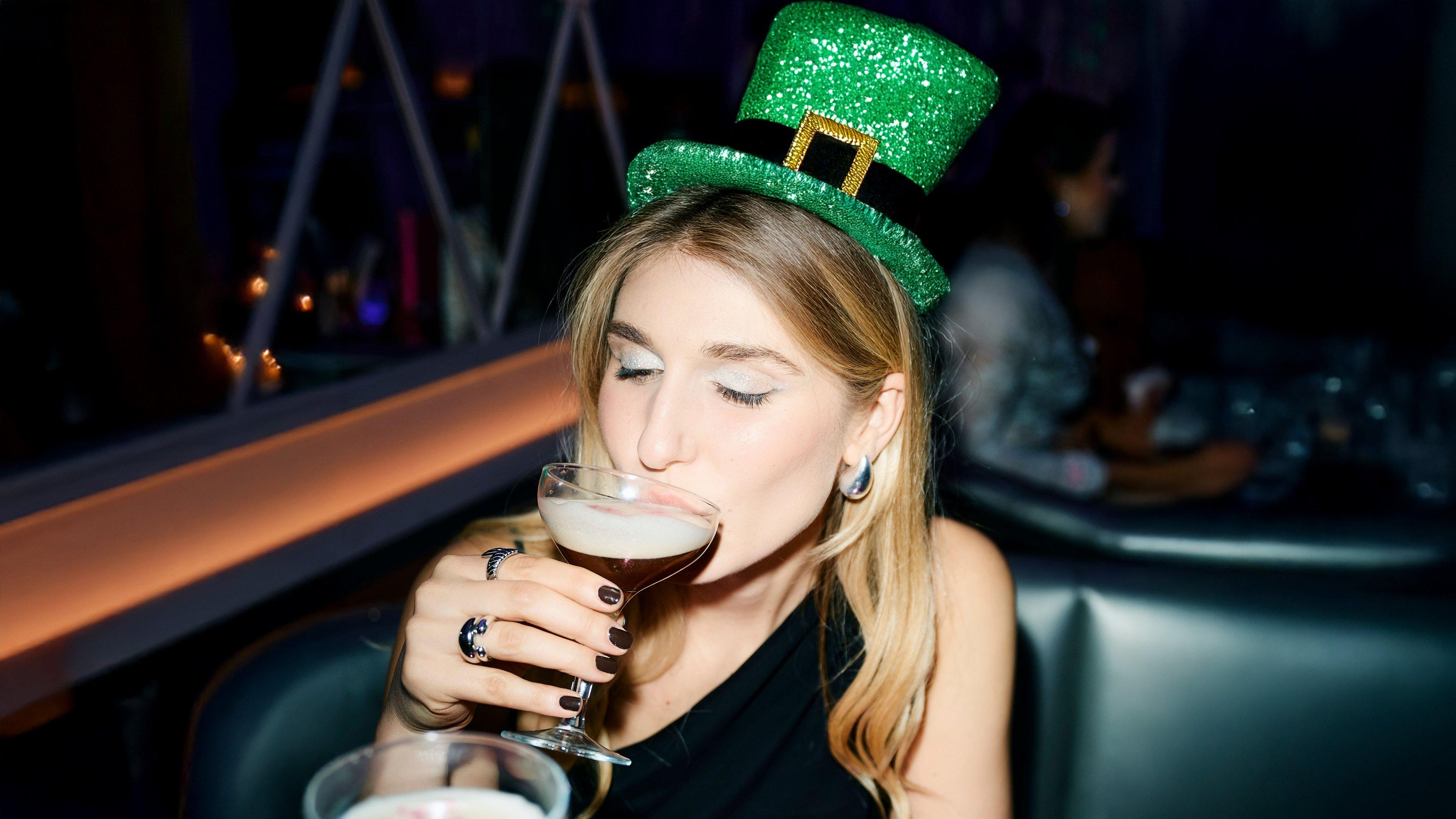 A guest sipping an Espresso Martini wearing a St Patrick's Day hat in Tonight Josephine