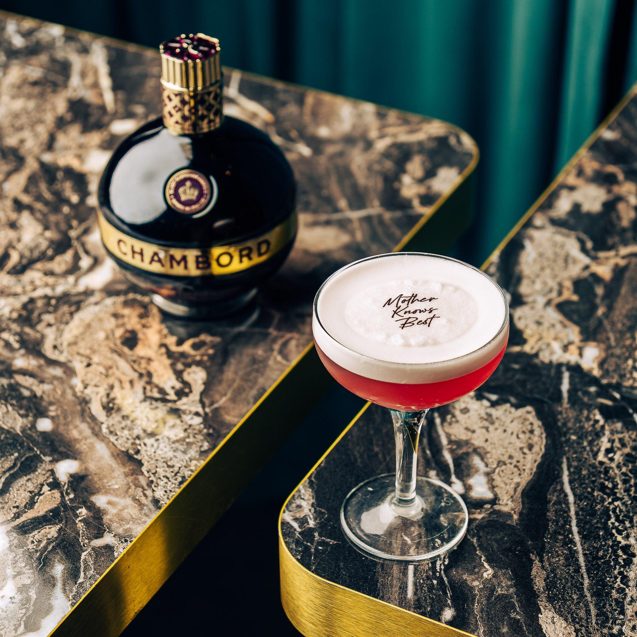 A Chambord cocktail with a Mother Knows Best garnish