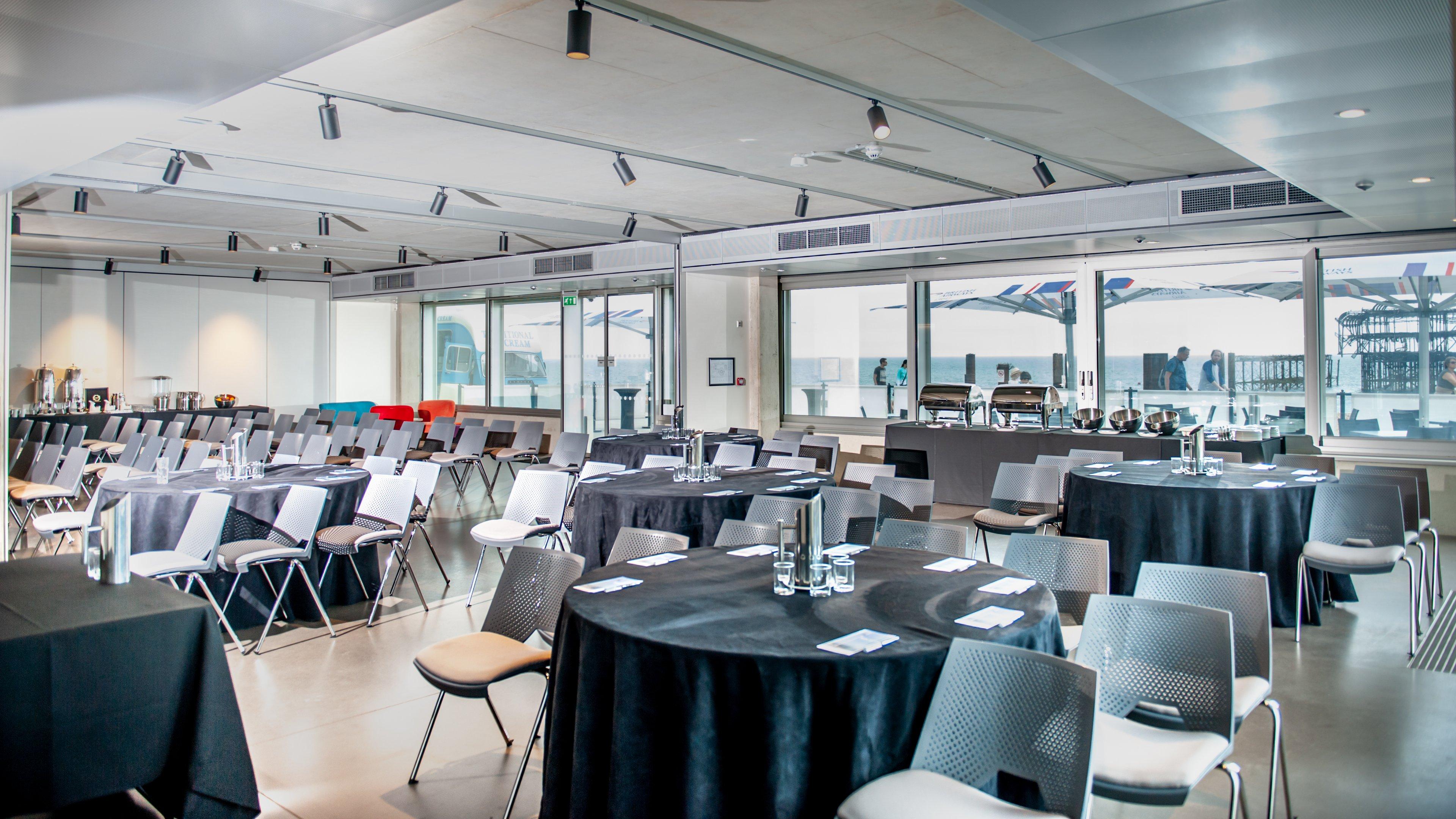 A meeting room on the beach front in Brighton with chairs and tables facing a presentation screen