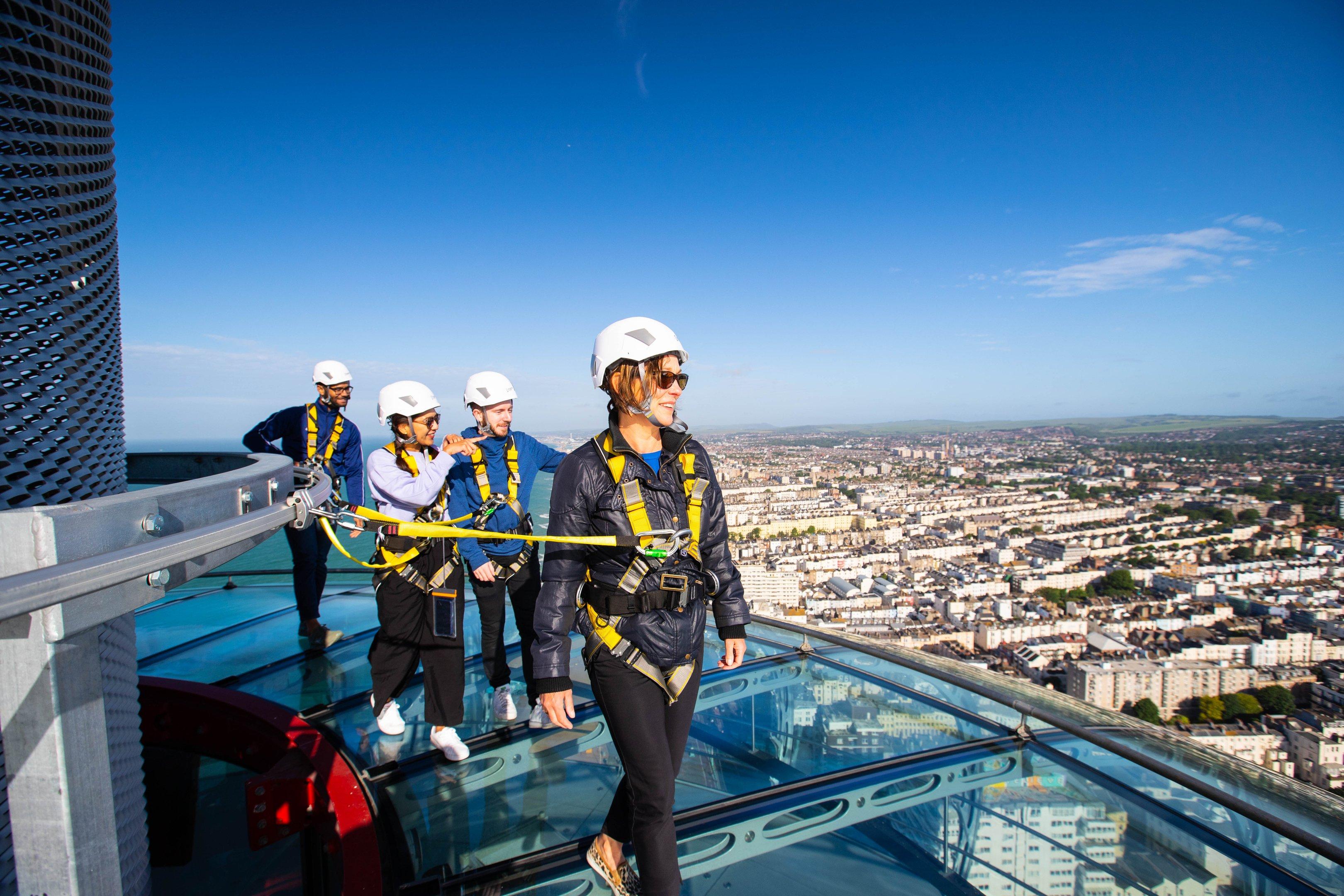 Guests walking around the top of the Brighton i360 as part of the Sky Walk experience