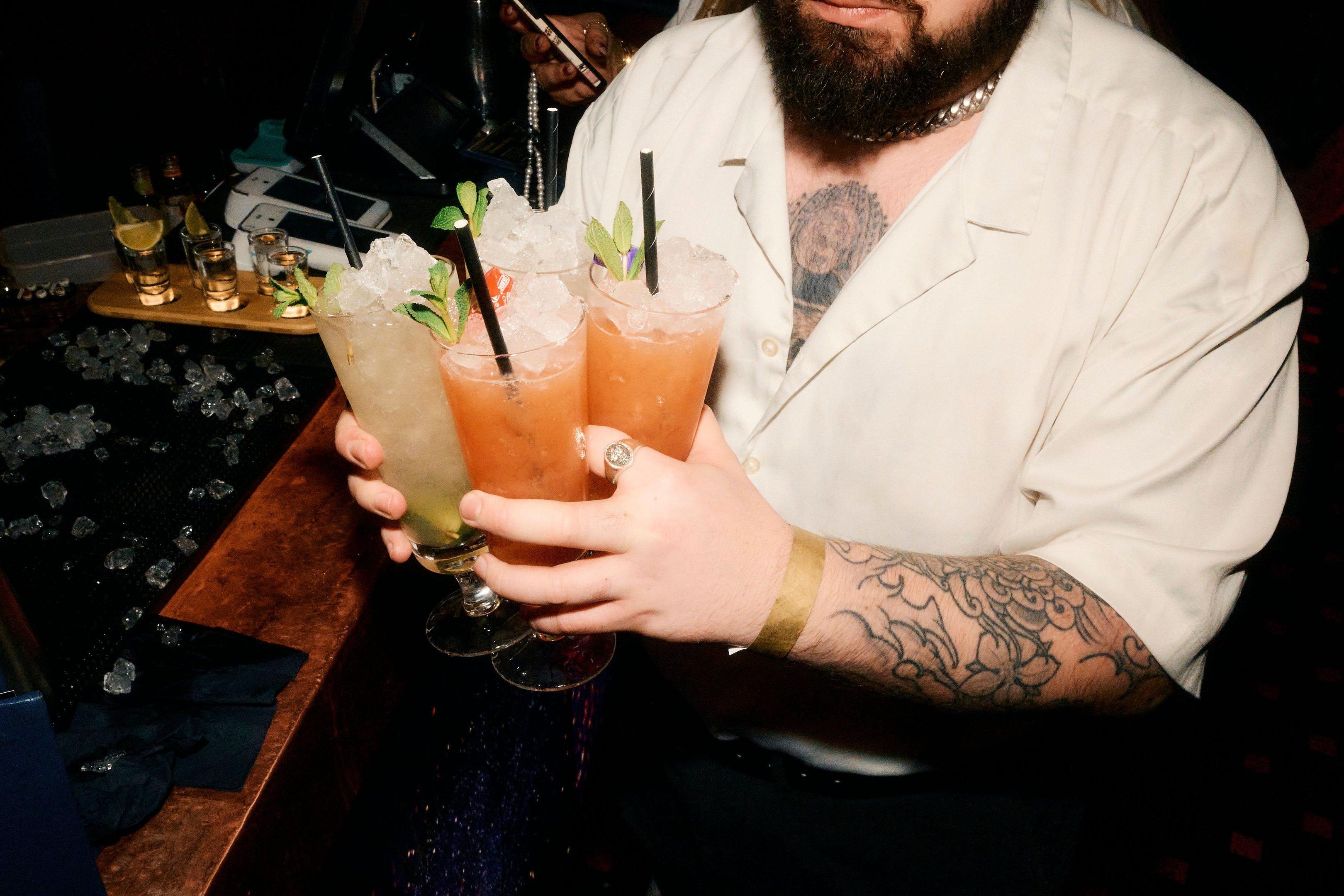 Man excitedly bringing cocktails back to his party 