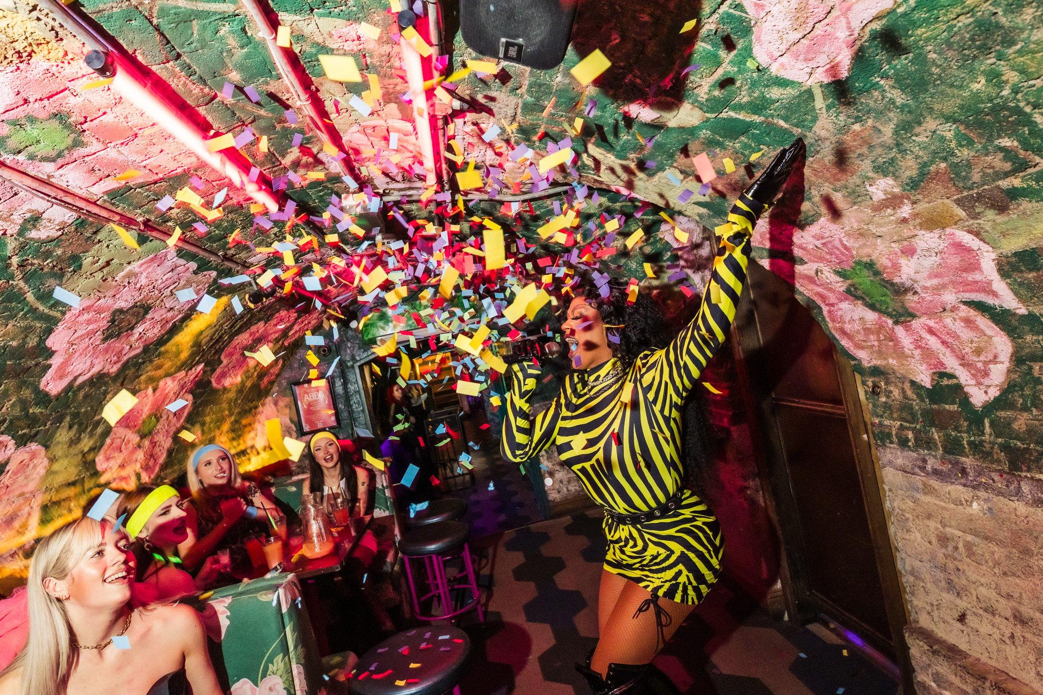 A drag queen performing in Blame Gloria surrounded by confetti