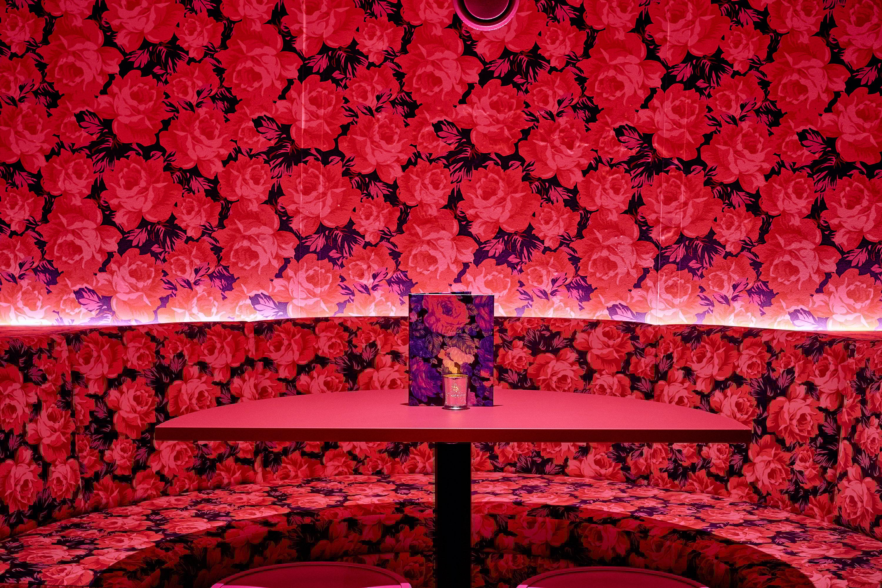 Bench seating with a pink rose pattern on the walls and seating