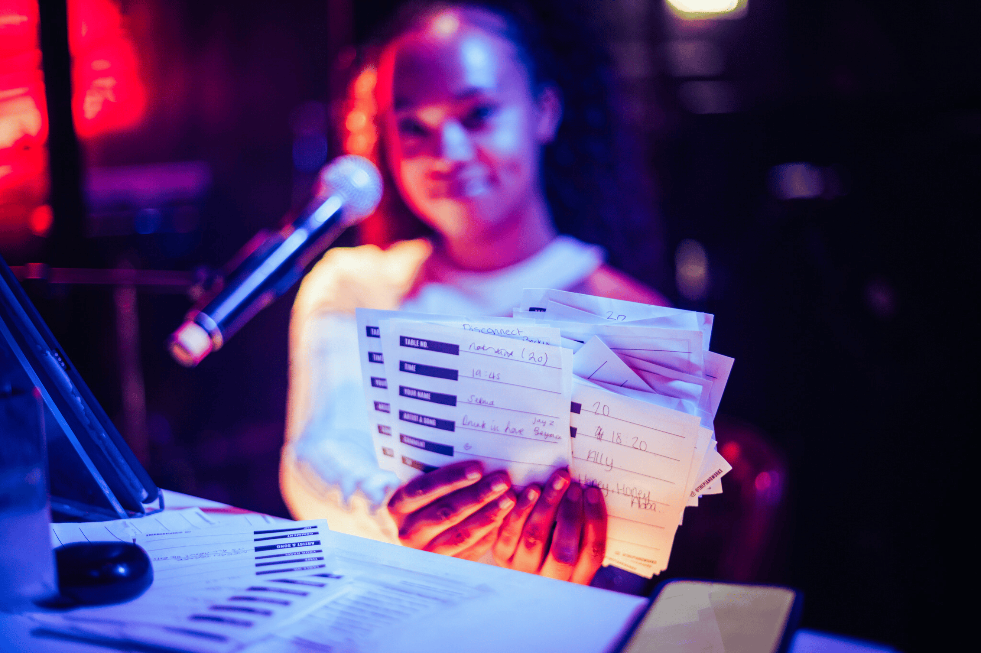 A female piano player holding up song request slips 