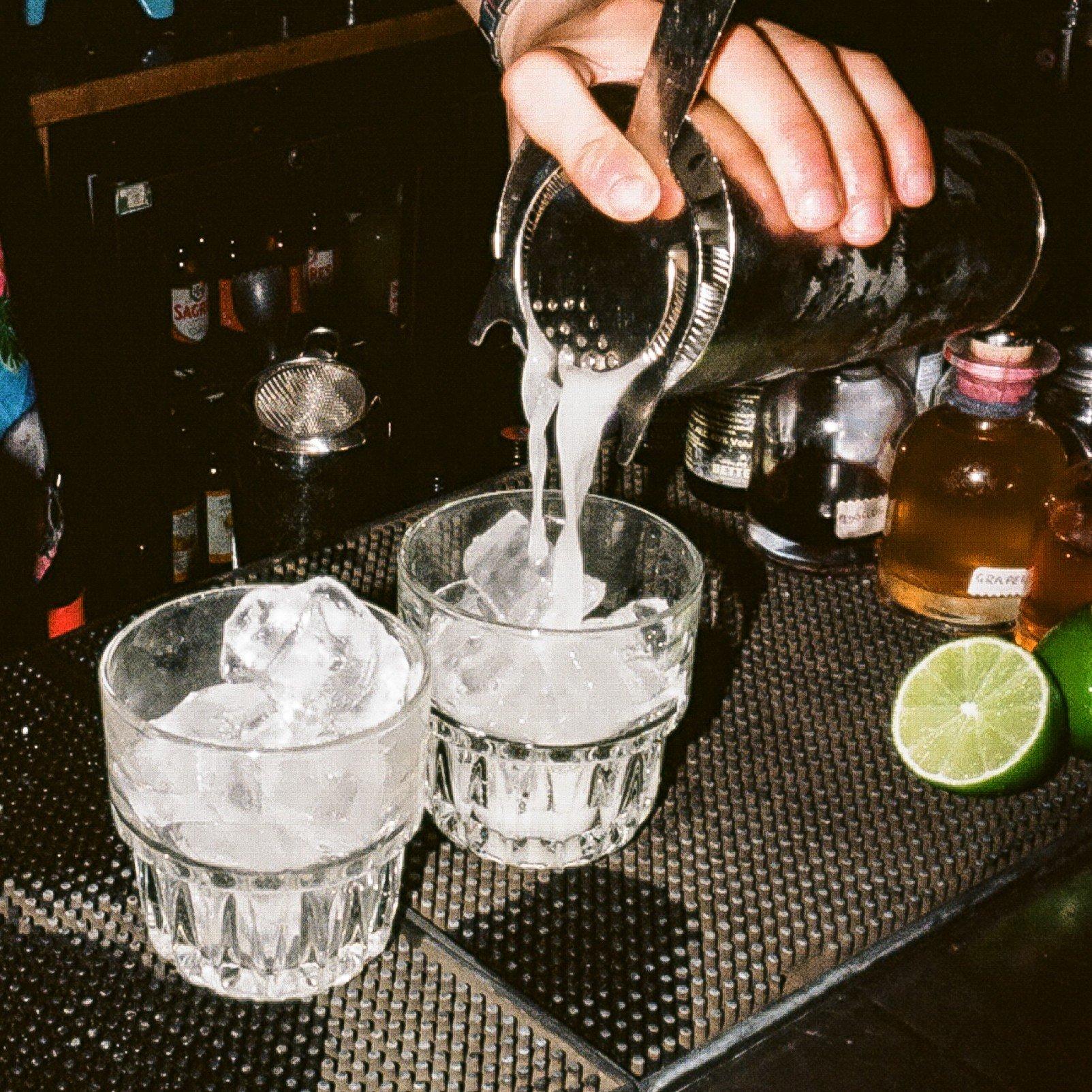 Two Tommy's Margaritas being poured on the bar in Barrio
