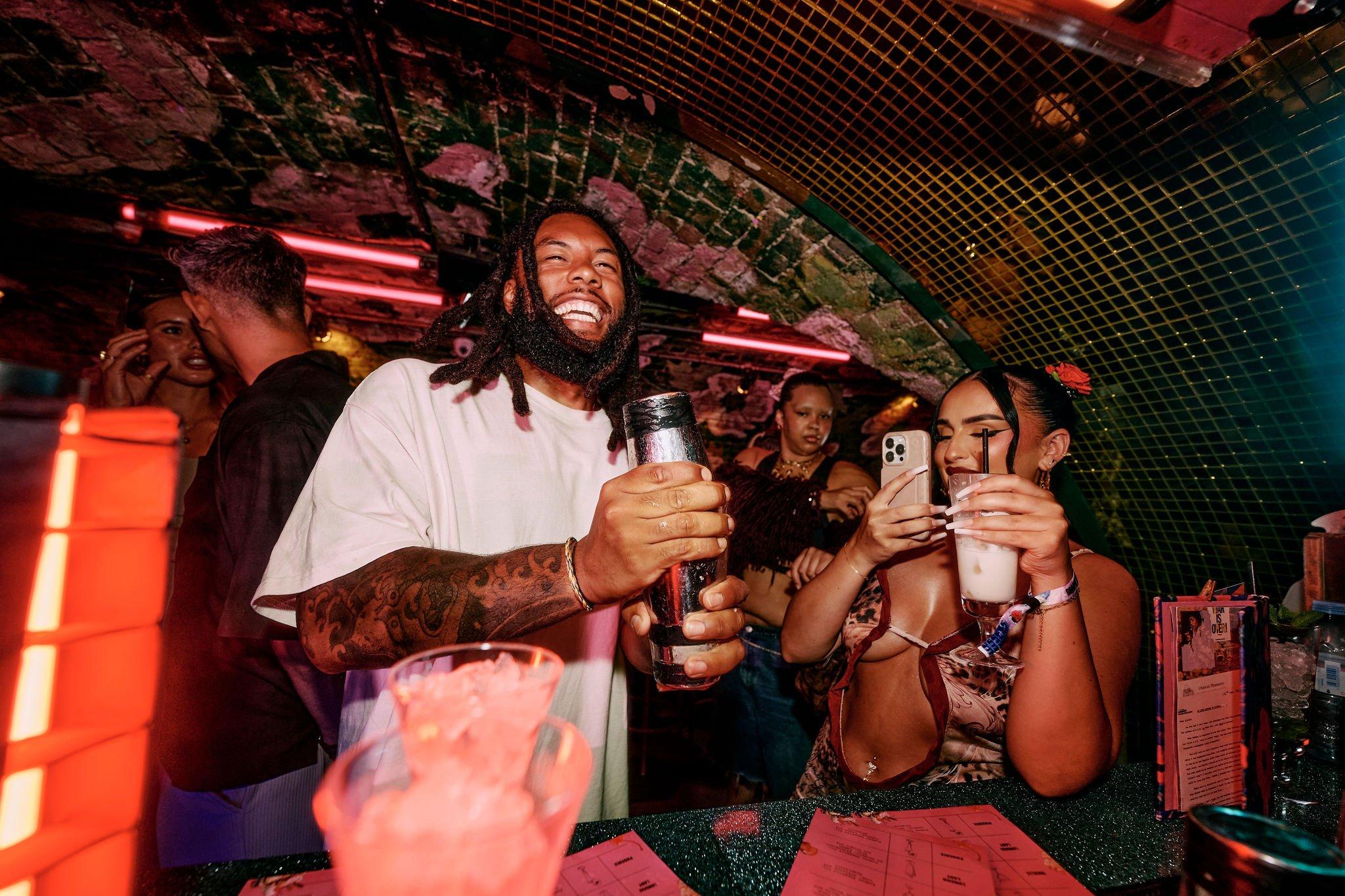 A guest shaking a cocktail at the bar in Blame Gloria