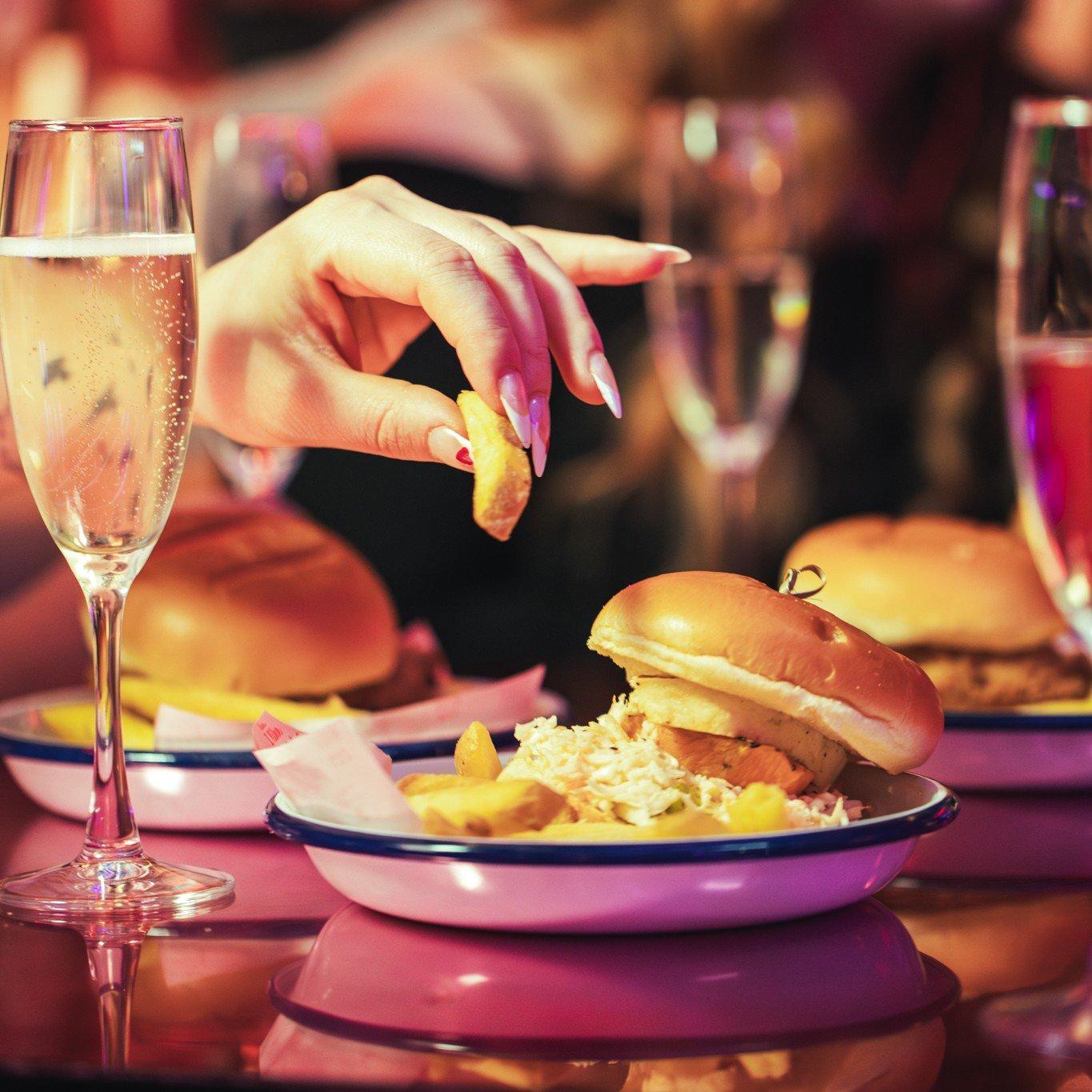 A bottomless brunch burger with a customer picking up a fry off the plate in Tonight Josephine